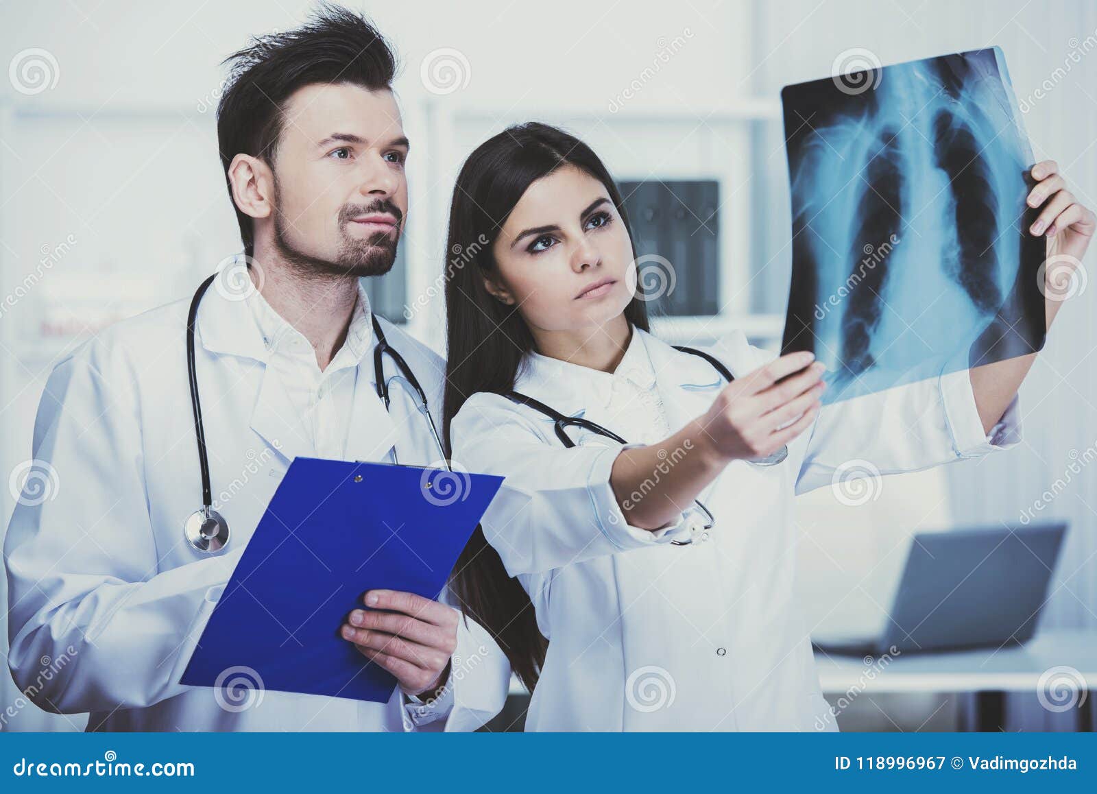 two young doctors are looking at roentgen in clinic.