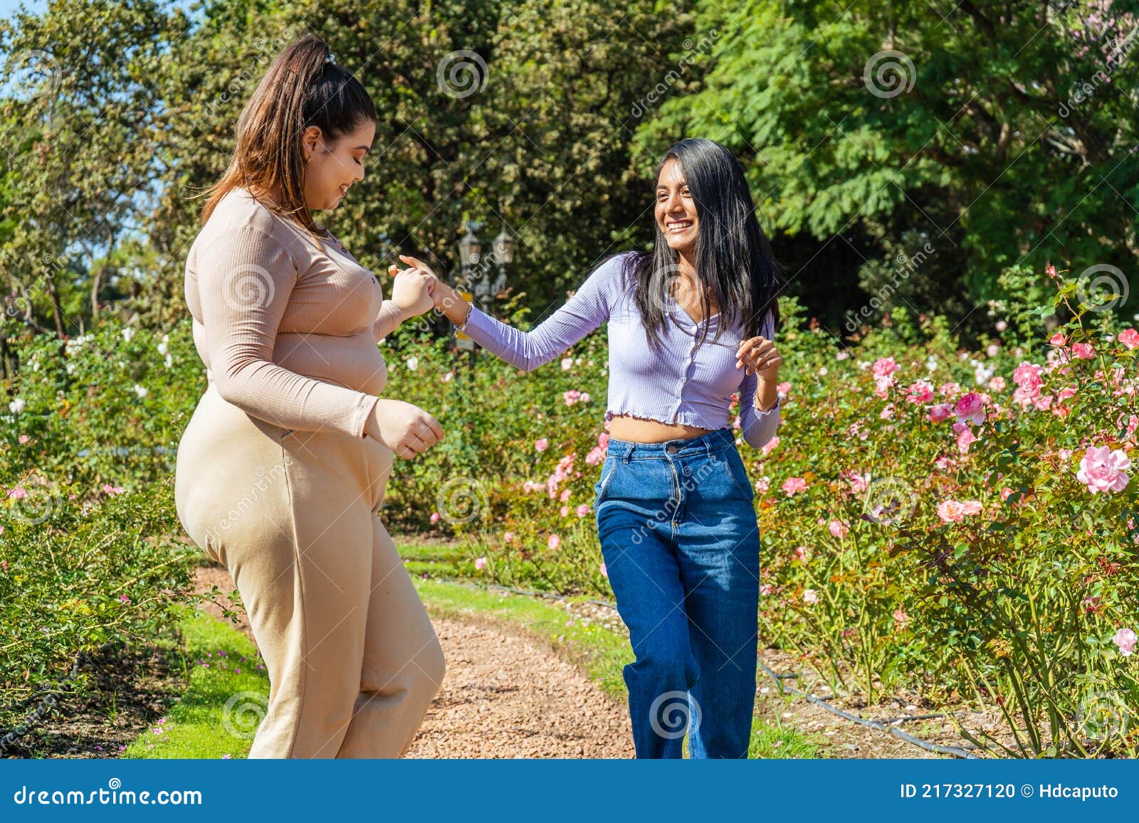 Two Young Girls Dancing In A Public Park Very Happy And Having Fun With