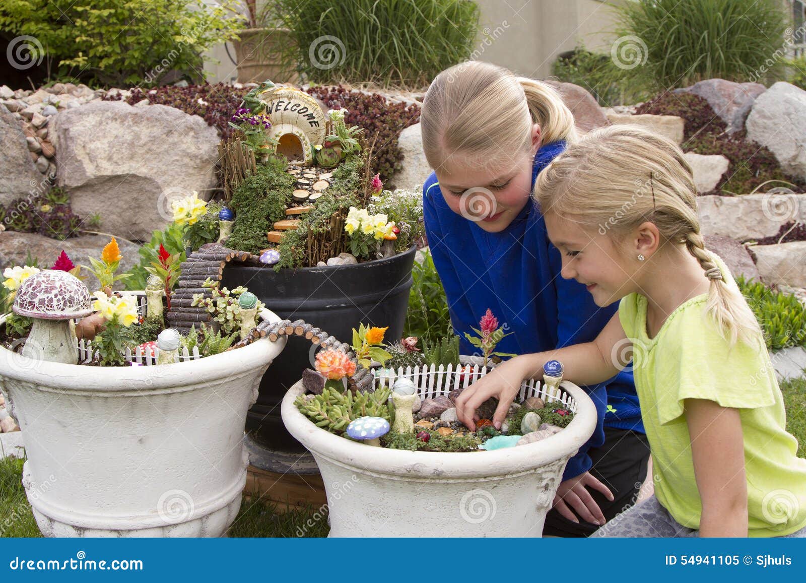 Two Young Girls Helping To Make Fairy Garden In A Flower Pot Stock