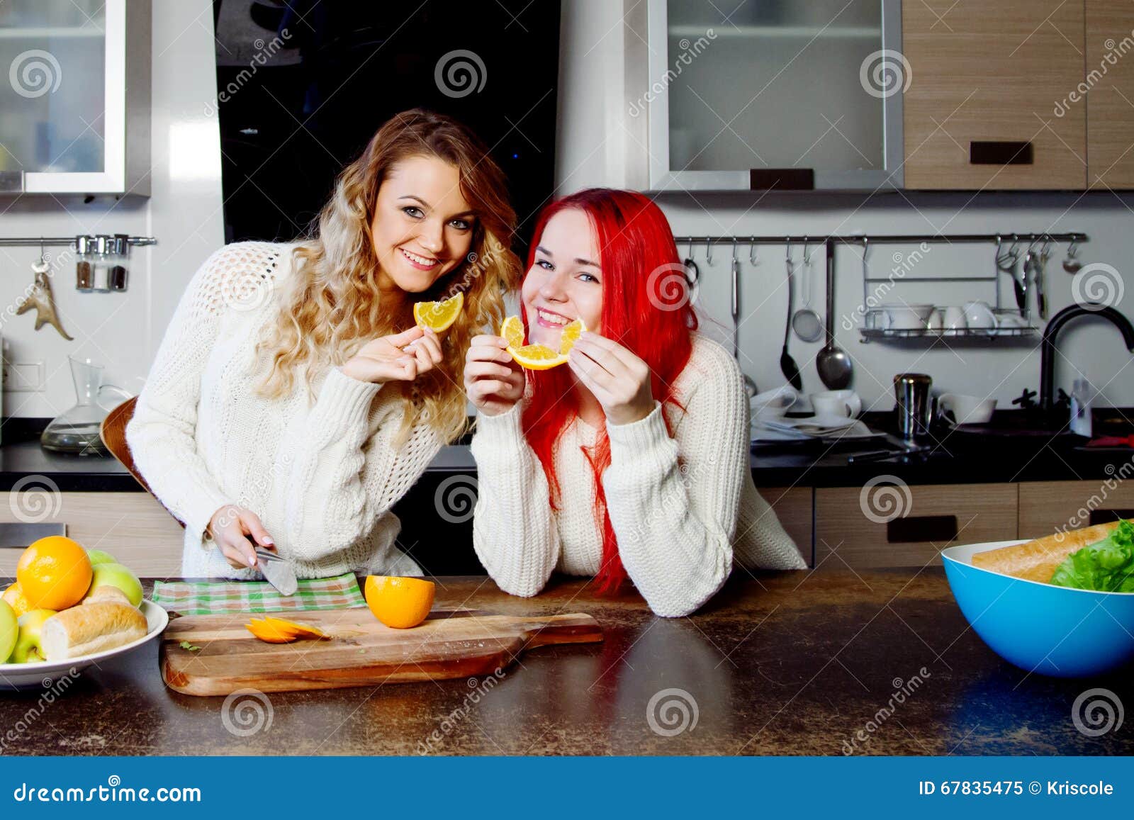 Two Young Girls In The Kitchen Talking And Eating Fruit Healthy Lifestyle Stock Image Image Of Home Cooking 67835475