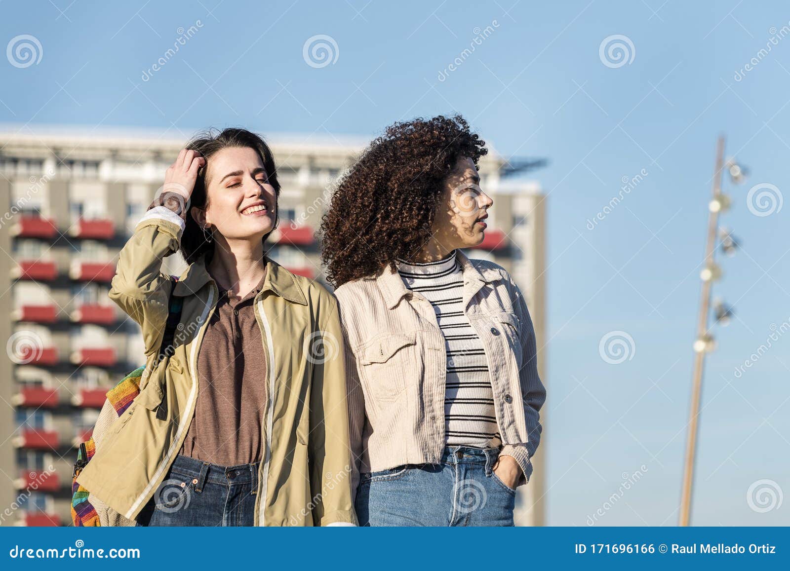 Two Young Girls Walking in the City Holding Hands Stock Photo