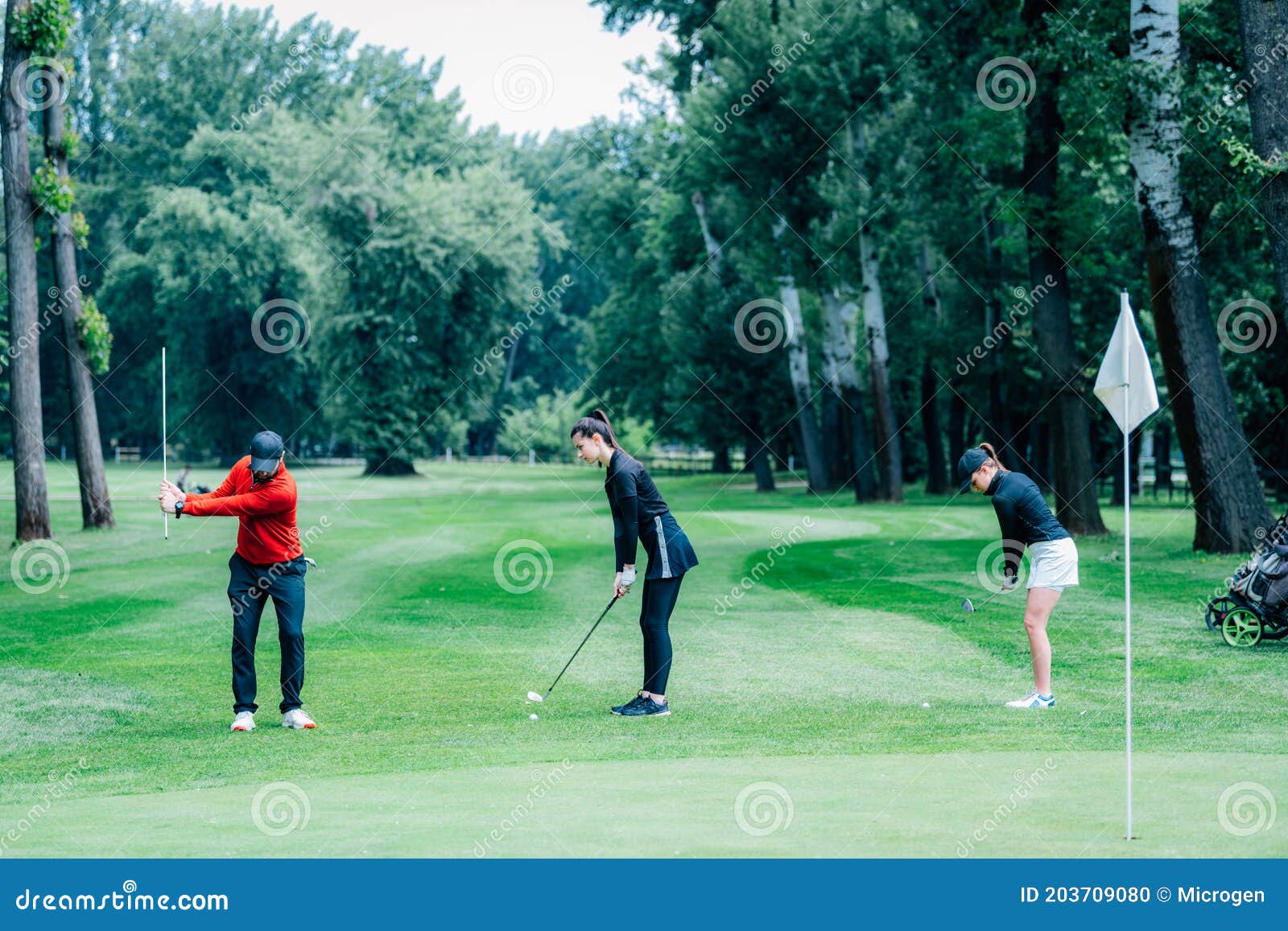 Two Young Golfers Practicing Chipping Shots on a Golf Course with Golf