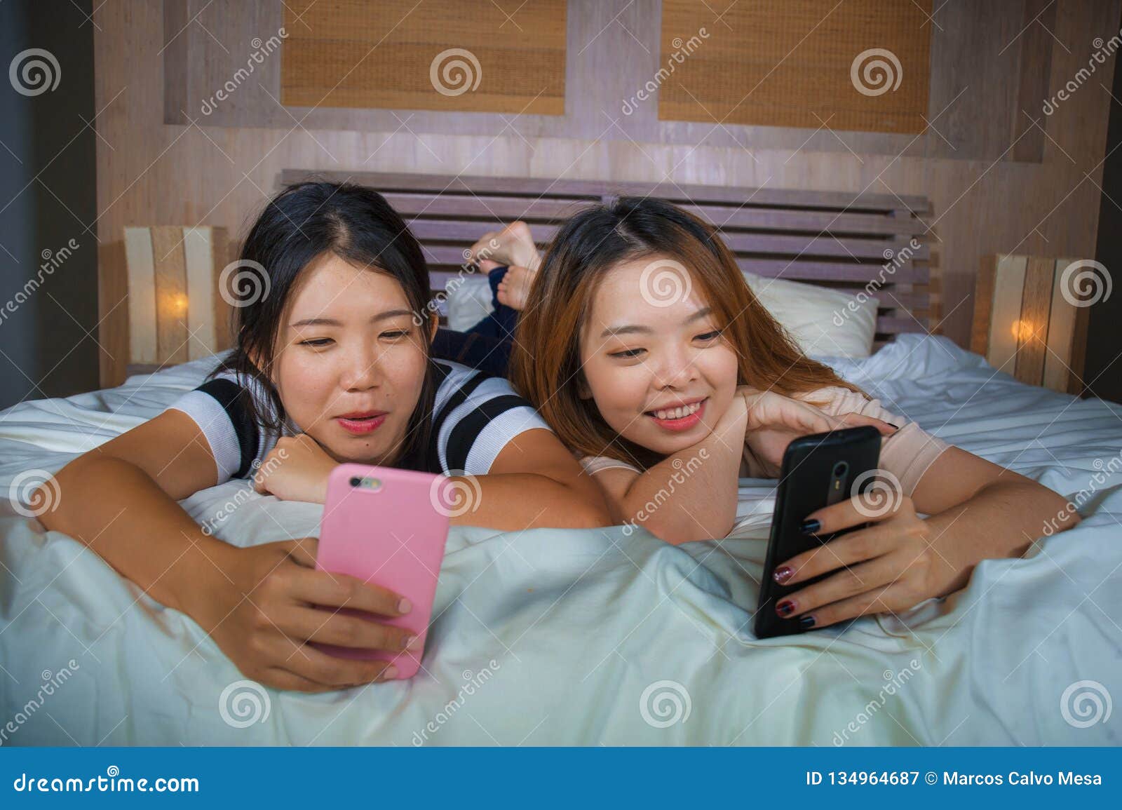 https://thumbs.dreamstime.com/z/two-young-happy-pretty-asian-chinese-girlfriends-sitting-home-bedroom-laughing-talking-having-fun-using-internet-social-134964687.jpg