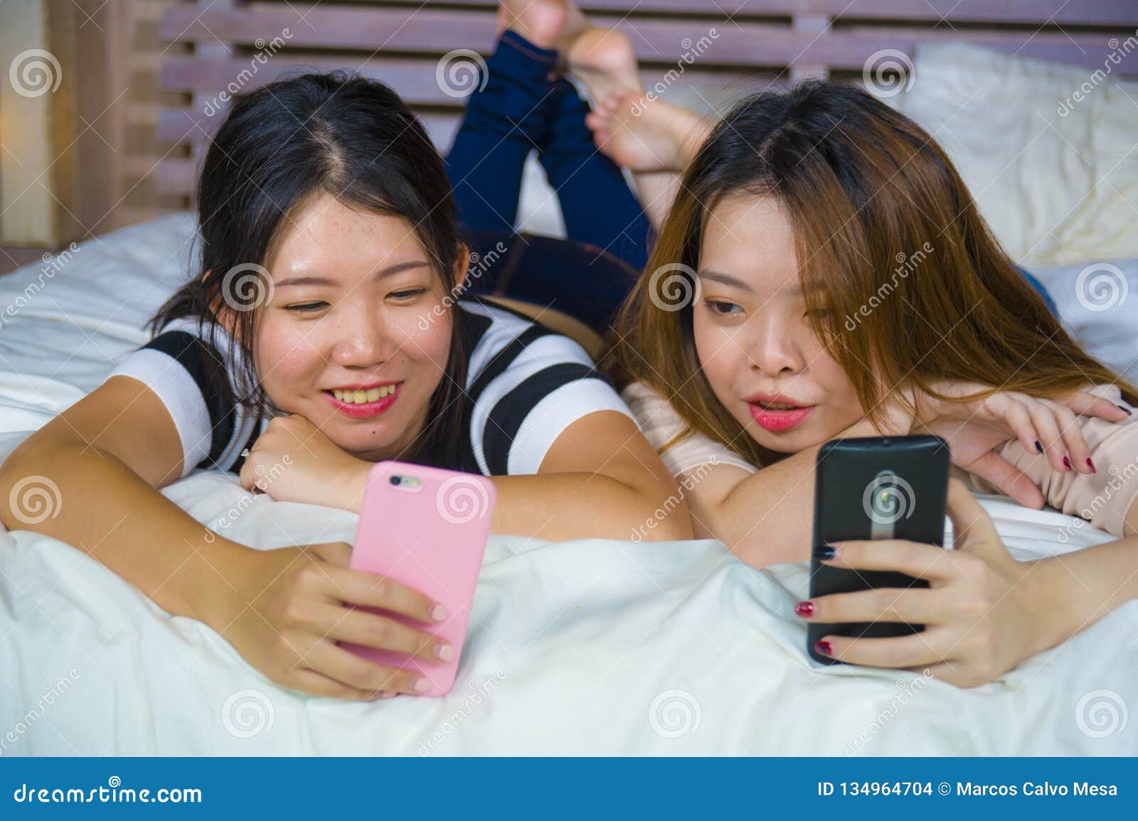 https://thumbs.dreamstime.com/z/two-young-happy-pretty-asian-korean-girlfriends-sitting-home-bedroom-laughing-talking-having-fun-using-internet-social-134964704.jpg