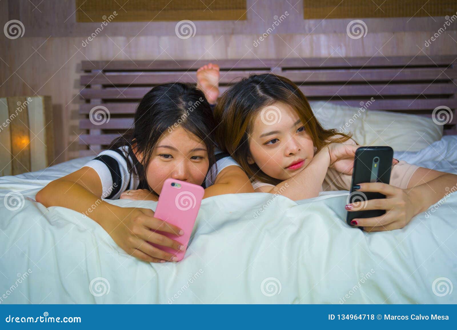 https://thumbs.dreamstime.com/z/two-young-happy-pretty-asian-korean-girlfriends-sitting-home-bedroom-laughing-talking-having-fun-using-internet-social-134964718.jpg