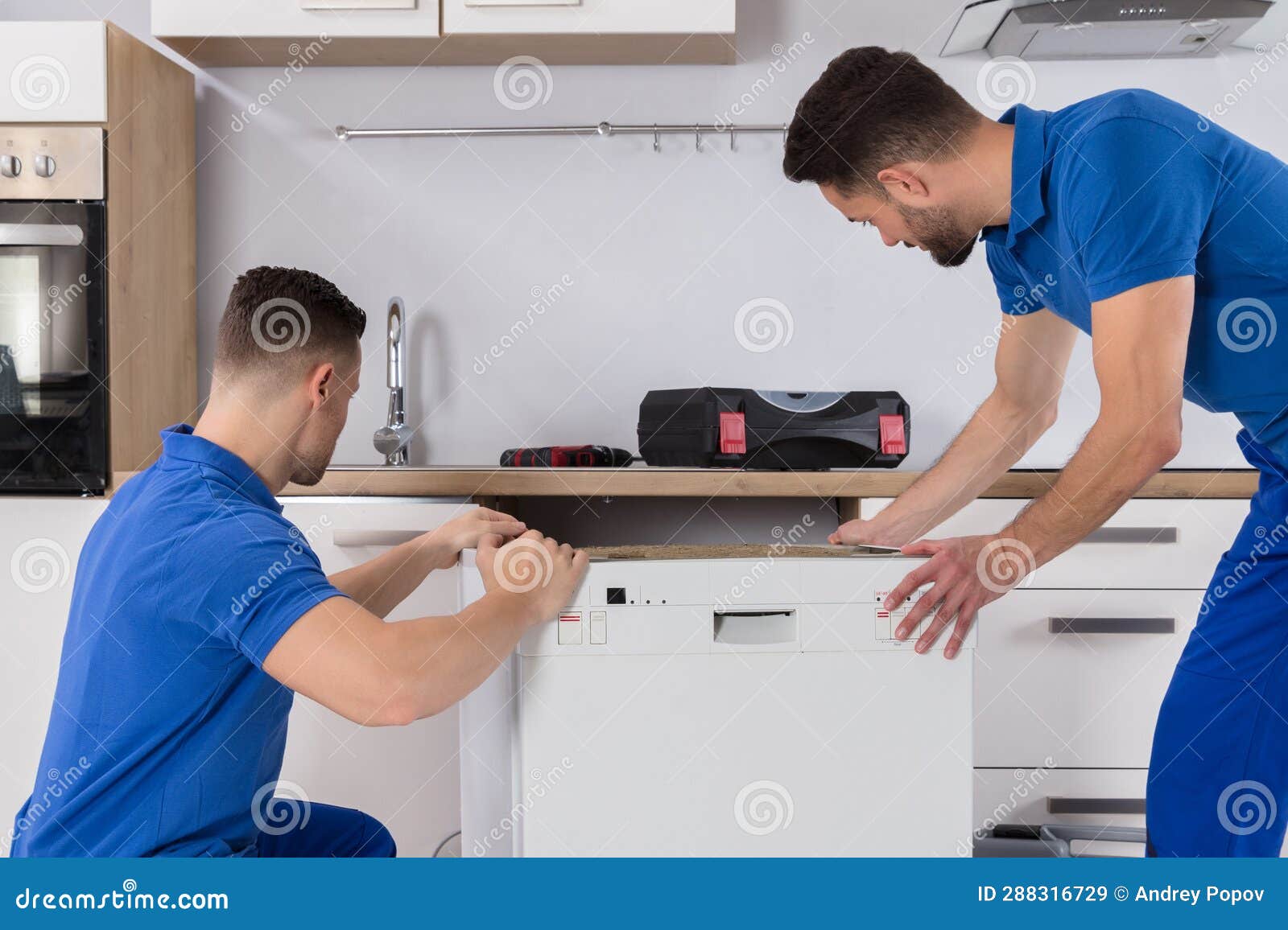 Two Movers Placing Dishwasher in Kitchen Stock Image Image of