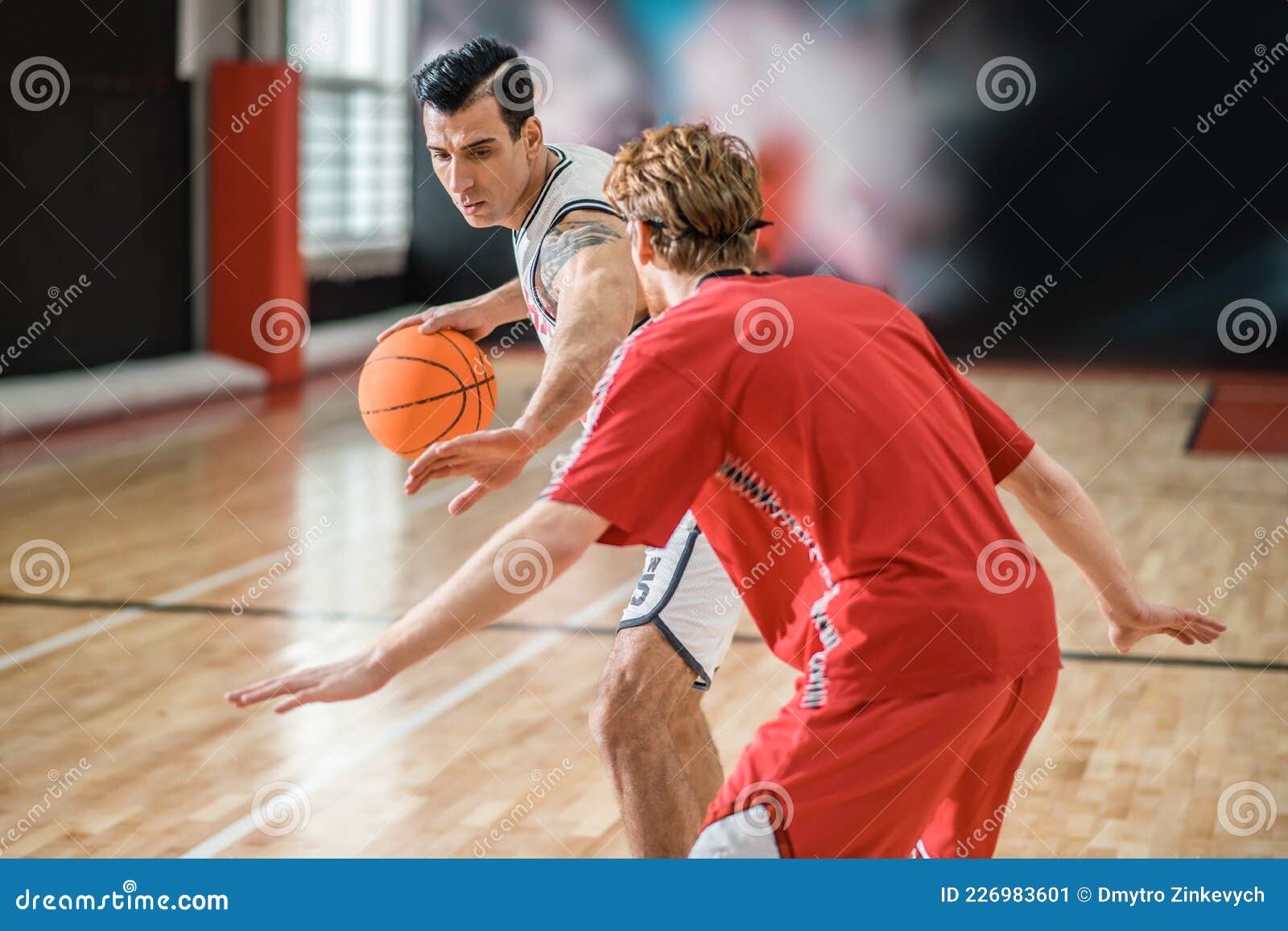 Two Young Men Playing Basketball and Looking Involved Stock Image