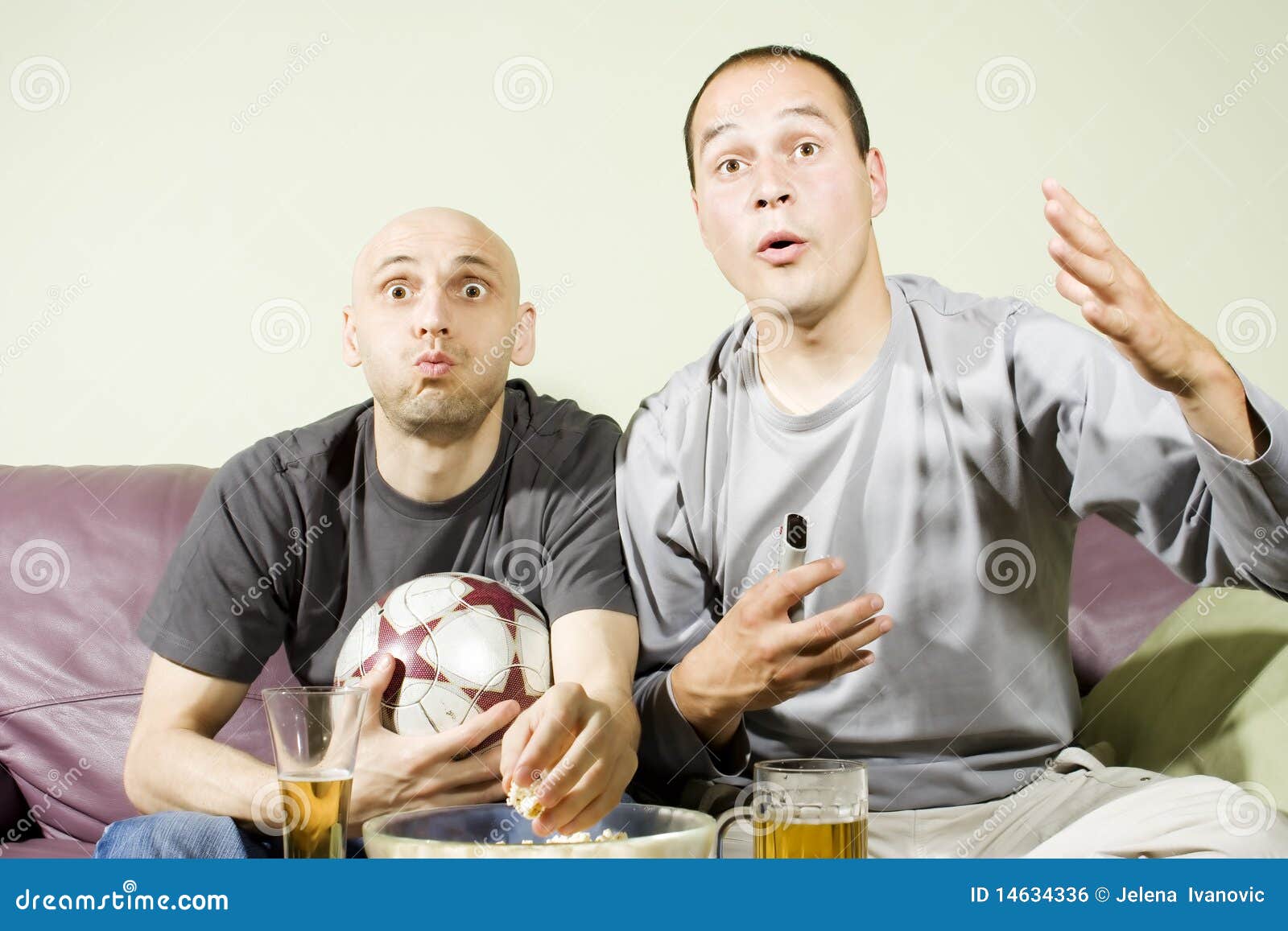 Two Young Men Watching a Football Match on Tv Stock Photo
