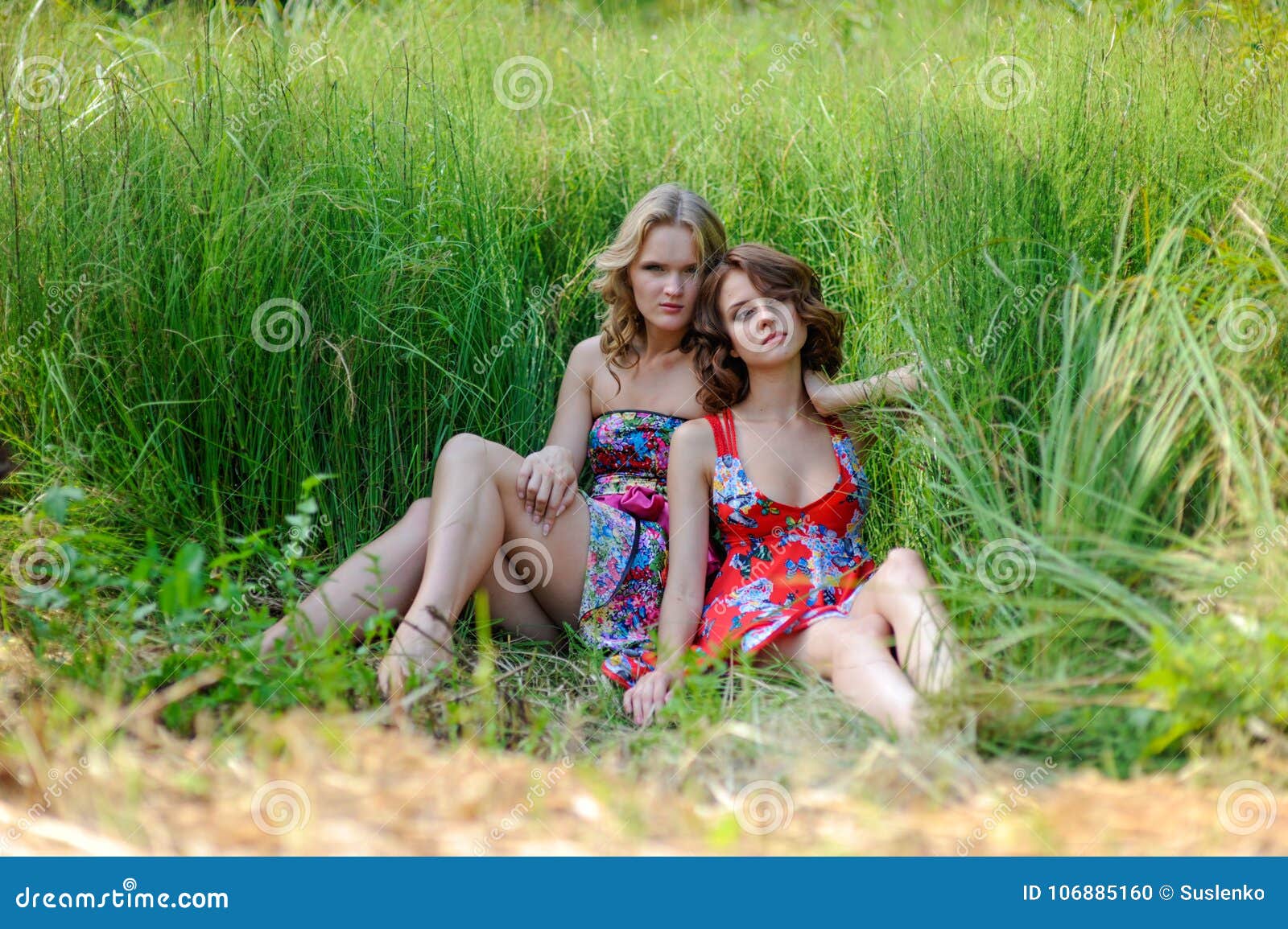 3 pretty blonde girls frolicking on the grass