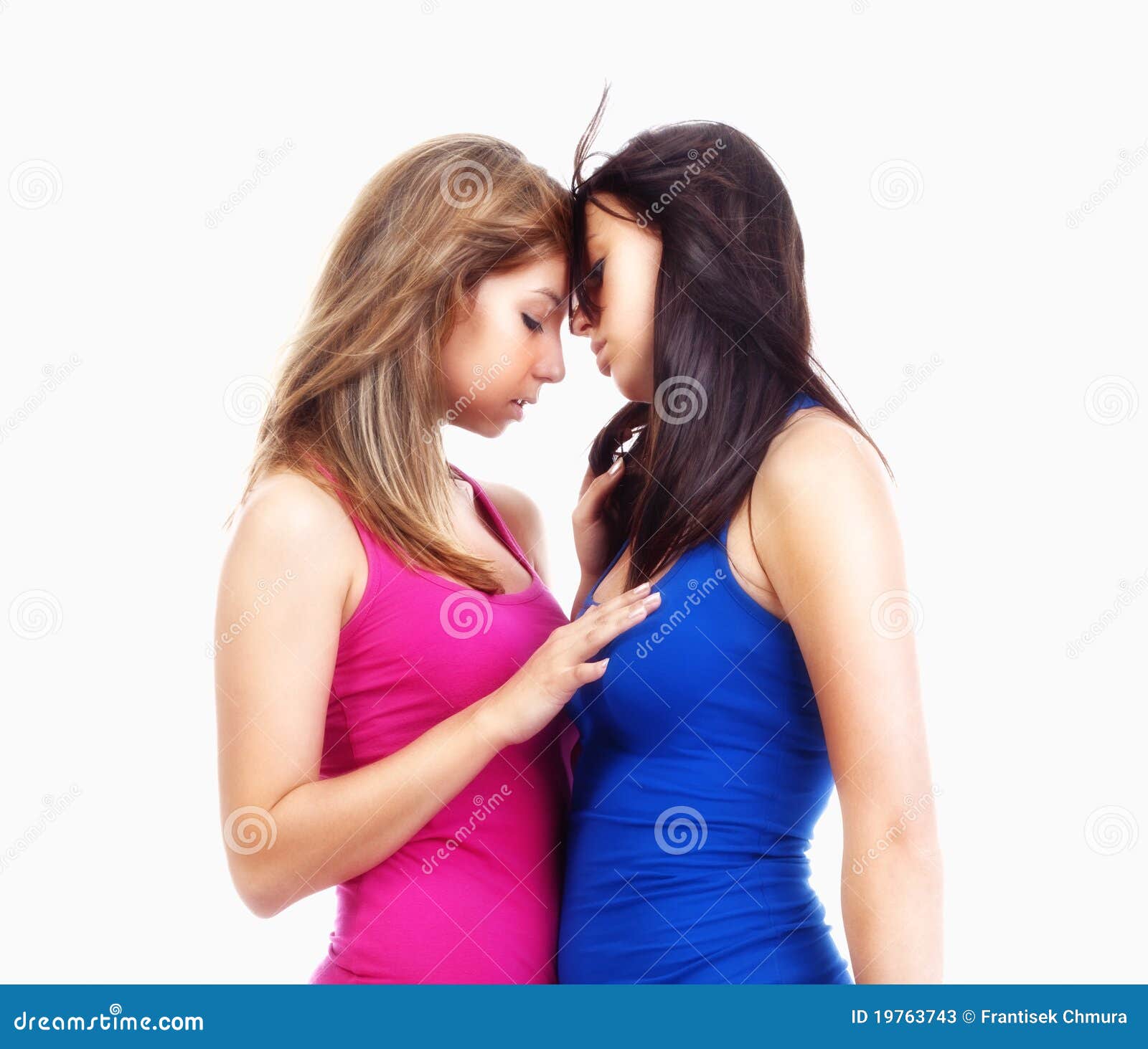 Photo about Two young beutiful women standing touching each other - isolate...