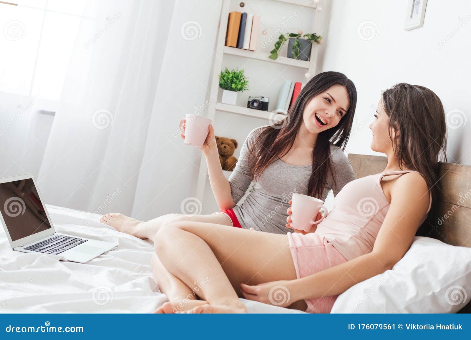 Lesbian Couple In Bedroom At Home Sitting Holding Cups