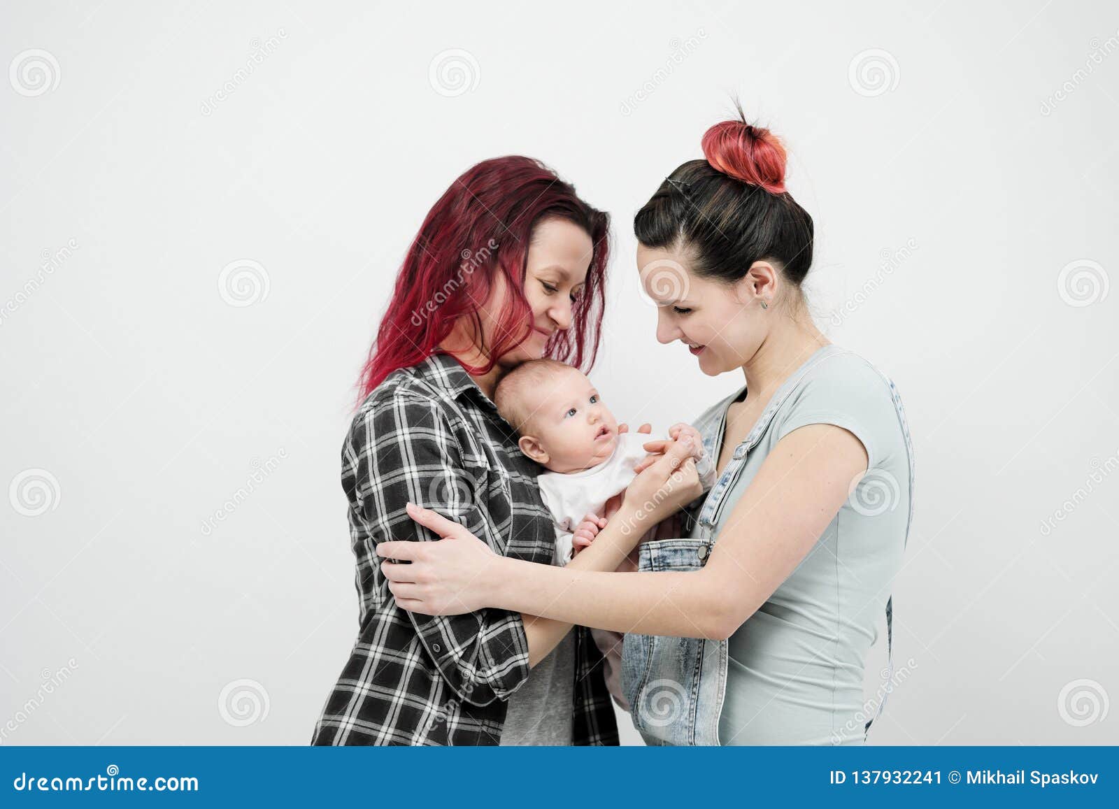 Two Young Women with a Baby on a White Background
