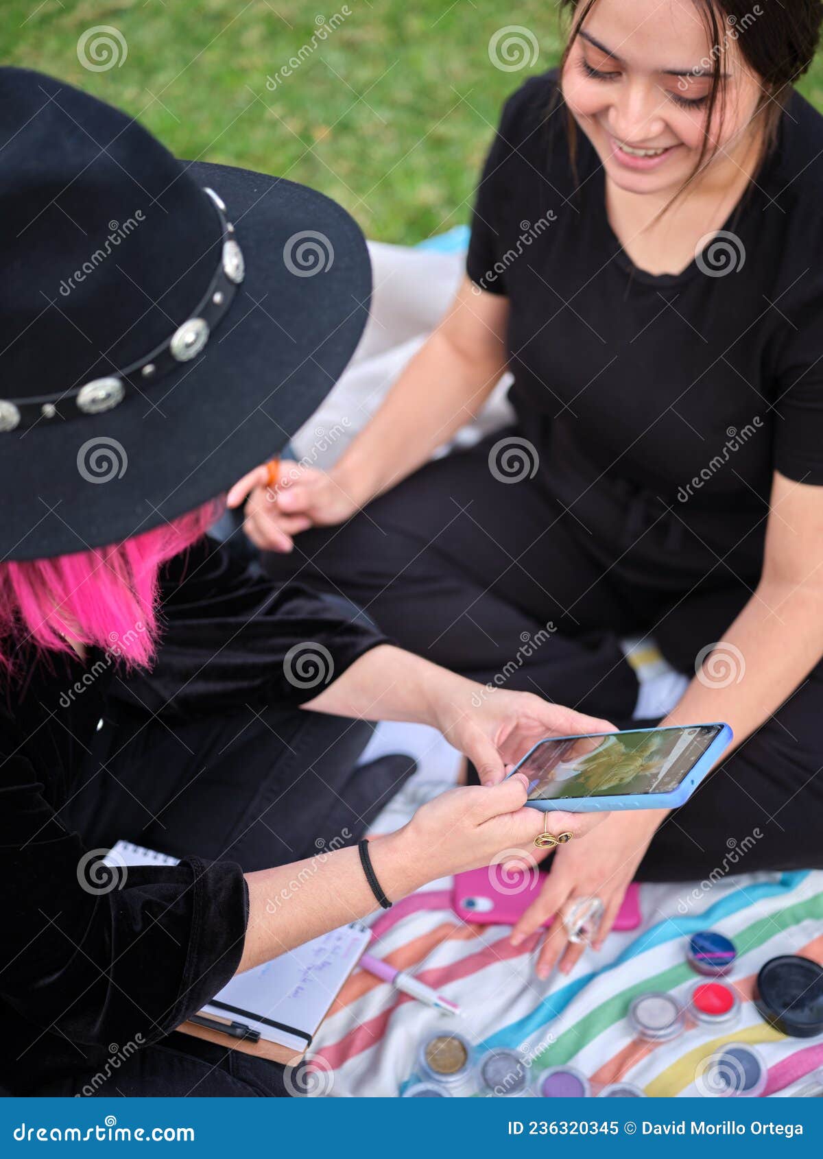 two young women looking at a  to characterize on the phone