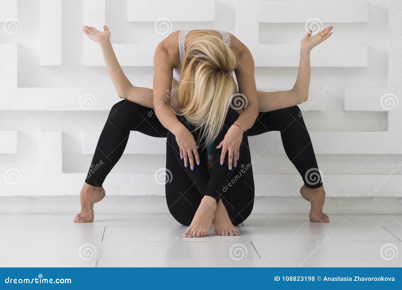 two young women practicing acro yoga balance pose whate background studio shoot two young attractive women practicing acro yoga 108823198