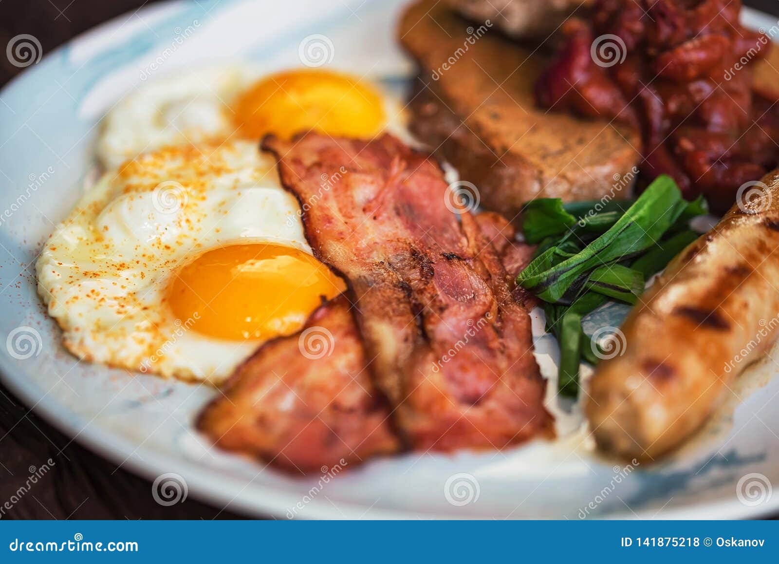 typial breakfast with eggs, bacon and sausage on plate