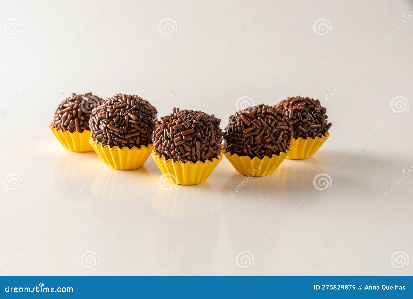 typical brazilian brigadeiros,  on white background and yellow mold