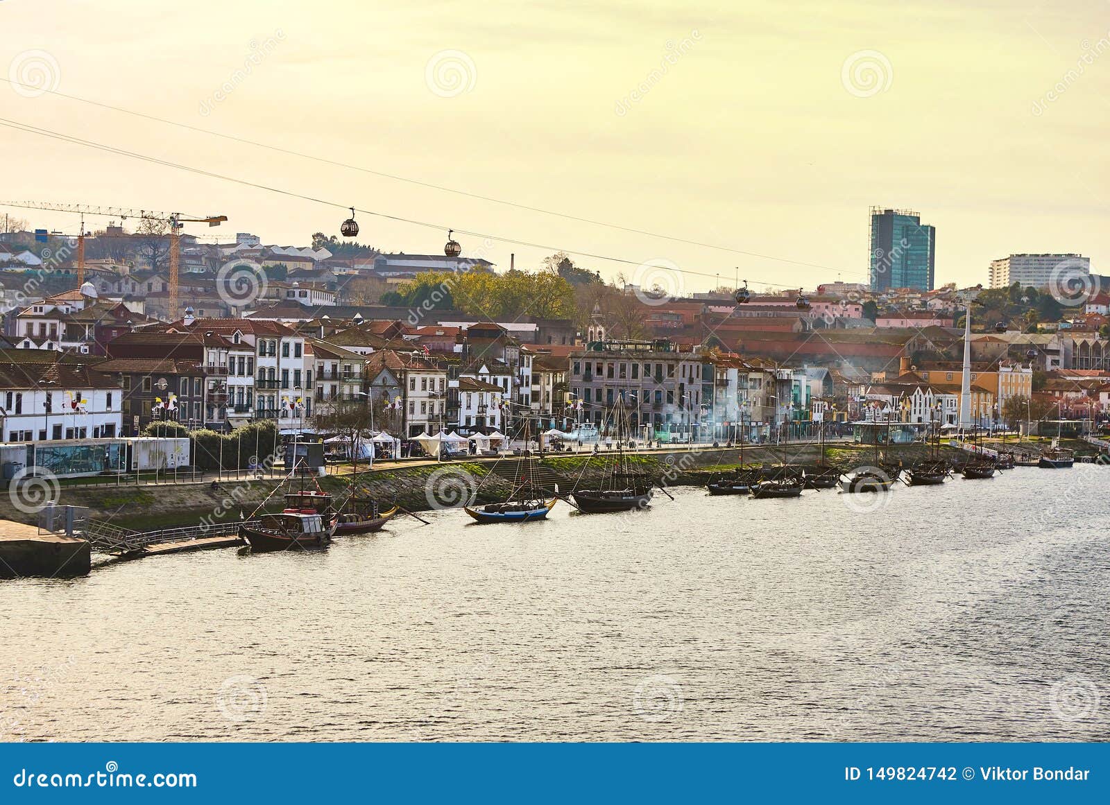 typical portuguese wooden boats, called `barcos rabelos `transporting wine barrels on the river douro with view on villa nova de g
