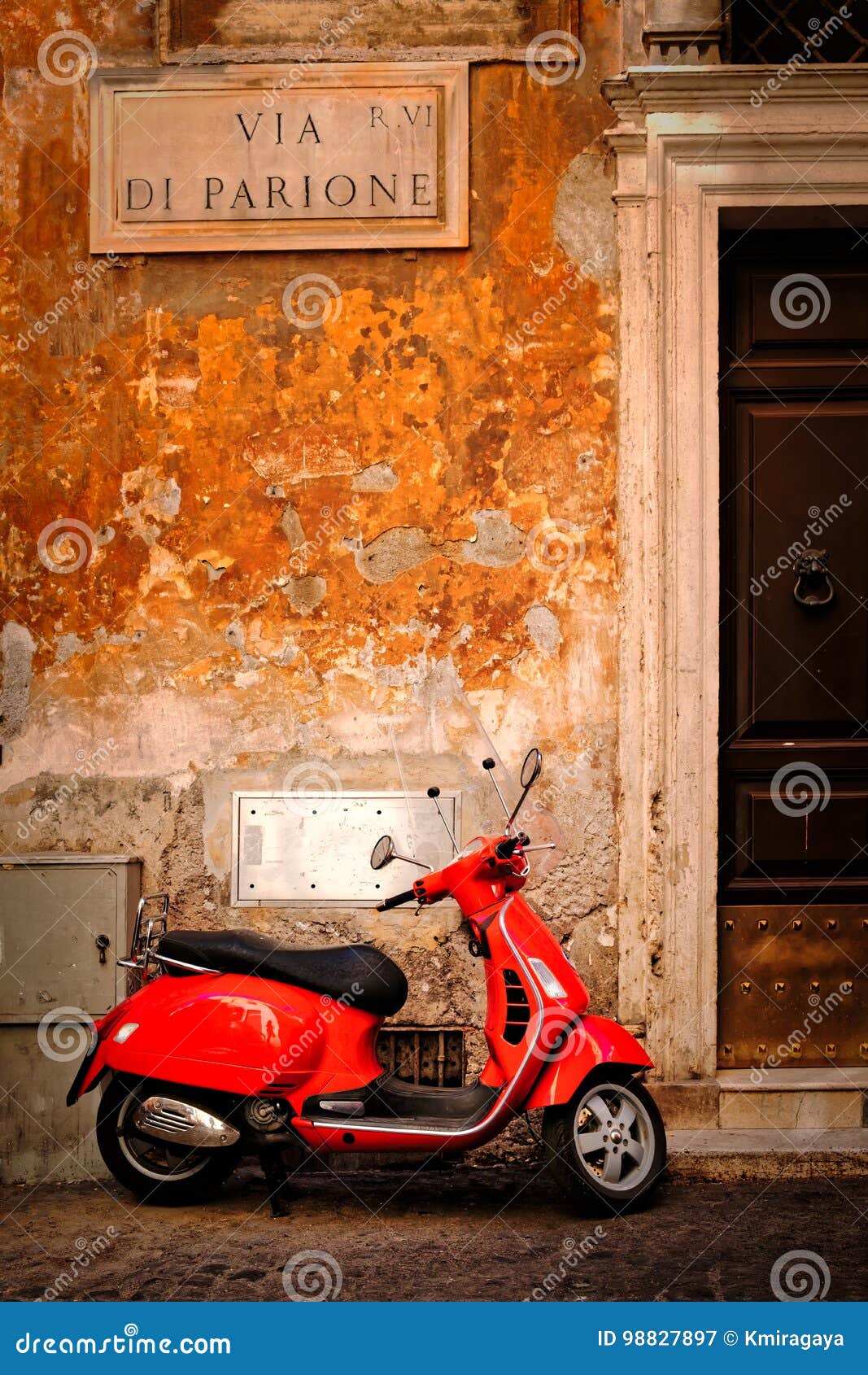 typical scene with a red scooter on a narrow central rome street