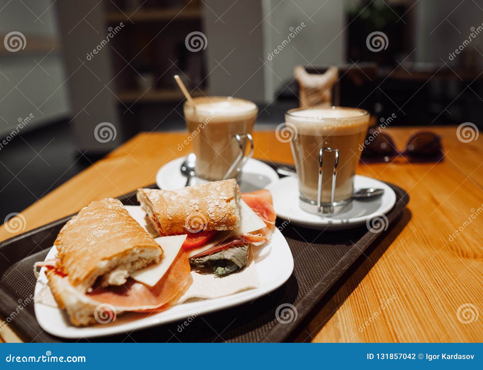 breakfest snack - coffee latte and bocadillo sandwich on table in one cafe