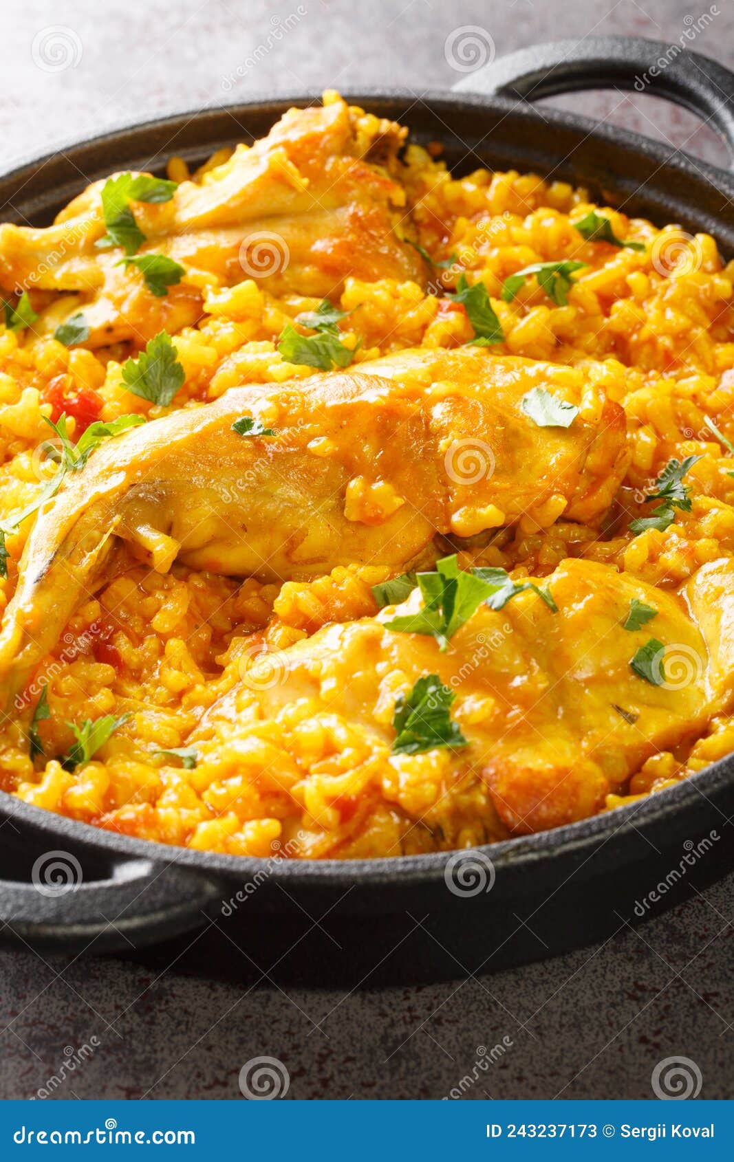 typical spanish rice with rabbit arroz con conejo closeup in the pan. vertical