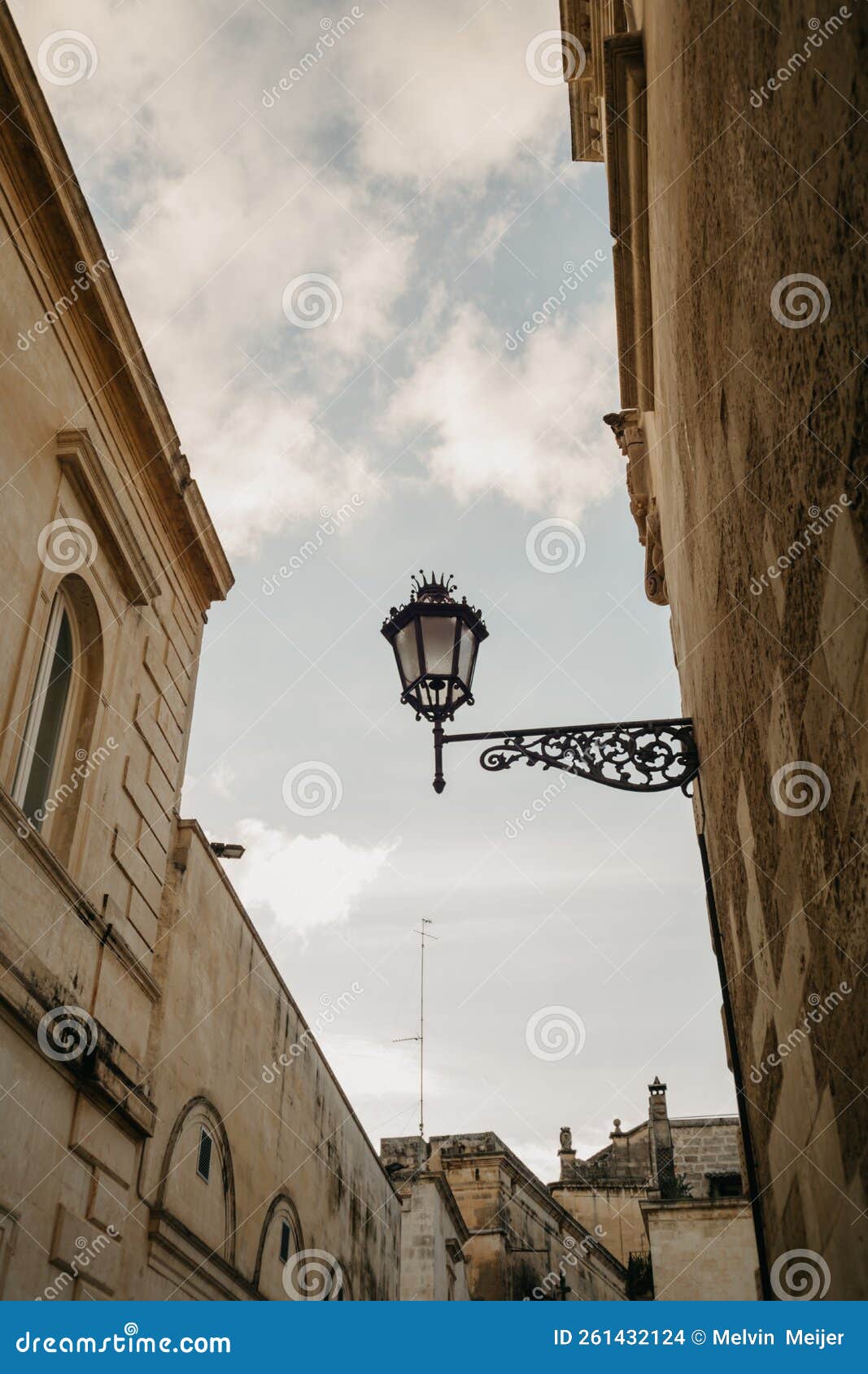 a typical street lamp with a crown on a wall in lecce with clear blue skies, italy