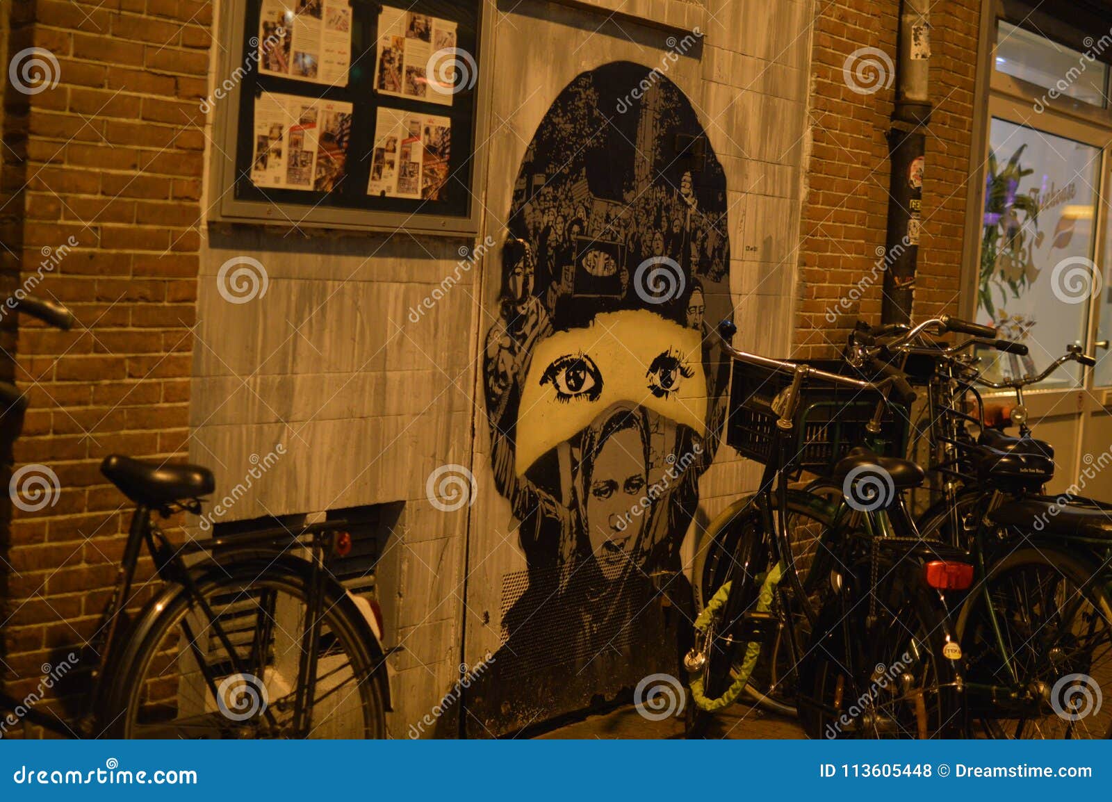 Tystade flickagrafitti Amsterdam. Grafitti av en flicka som bär en maskering, väggkonst i Amsterdam, Nederländerna