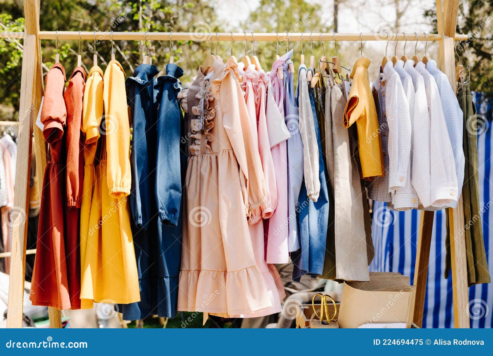 Ubrania Dla Dzieci Szyte Są Własnymi Rękami. Sprzedaż Odzieży Z Tkanin  Naturalnych. Obraz Stock - Obraz złożonej z rynek, dziewczyna: 224694475