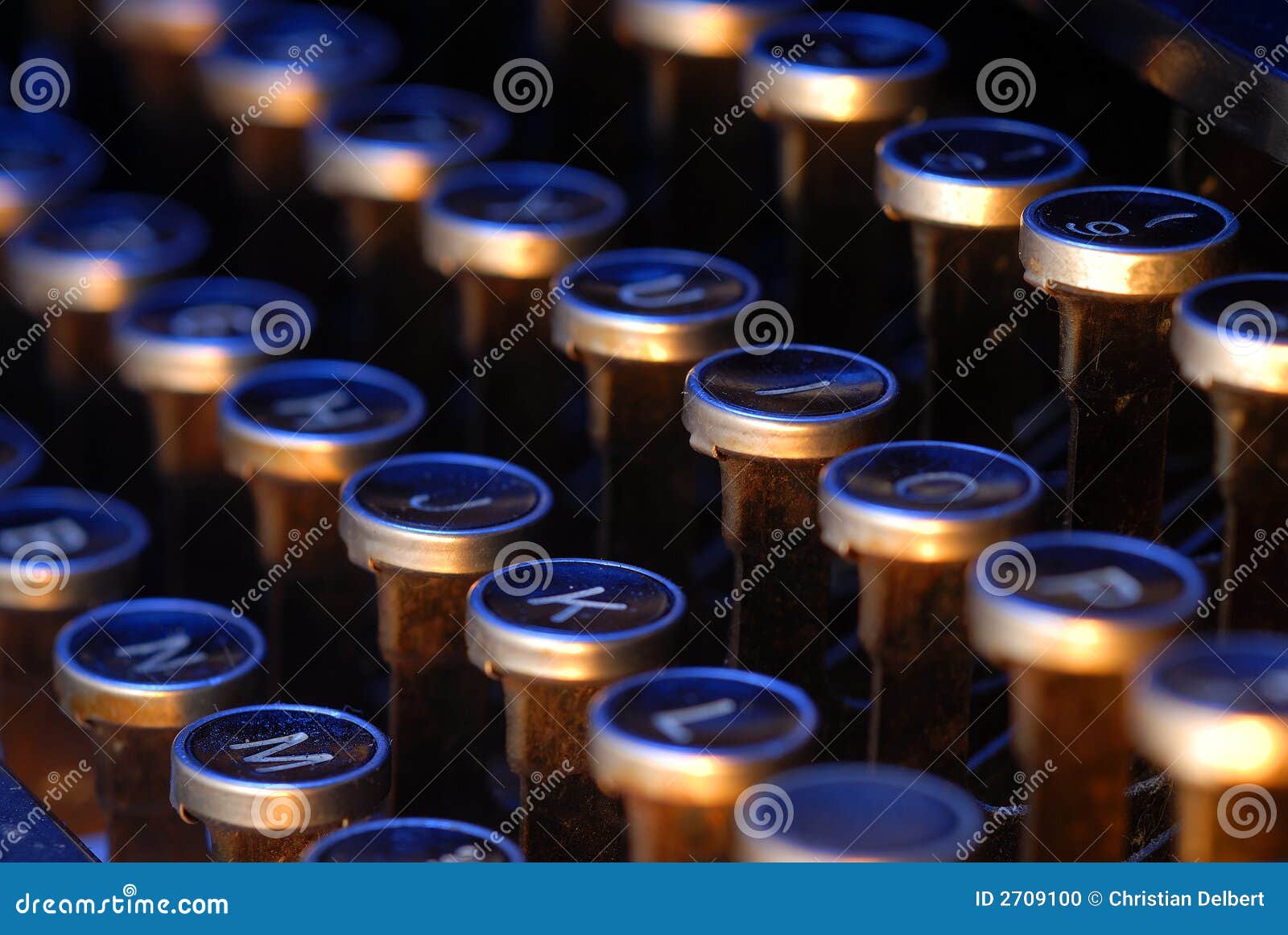 Uitstekende schrijfmachinesleutels. Oude sleutels van een uitstekende schrijfmachine die met oranje en blauwe lichten wordt aangestoken