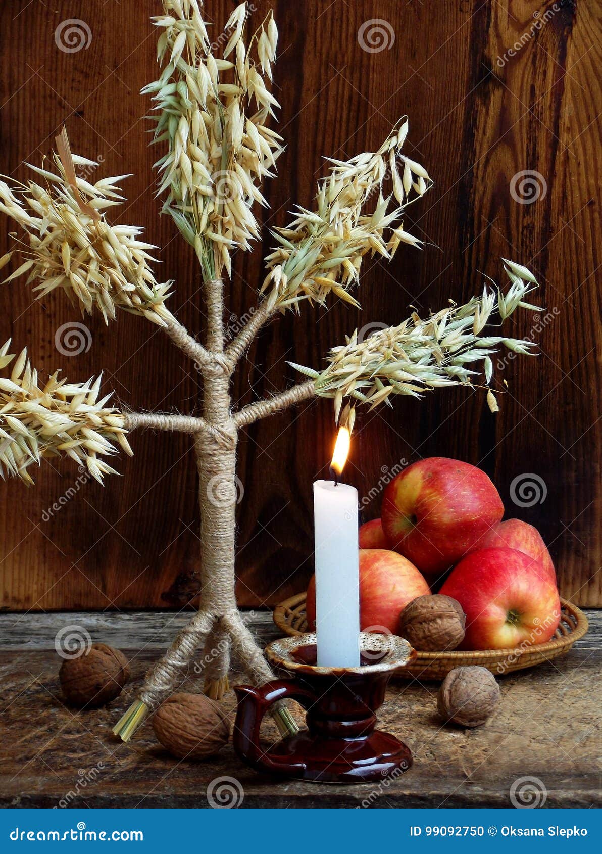 ukrainian christmas concept for greeting card. composition of xmas  didukh, burning candle, apples, walnuts on wooden backgr