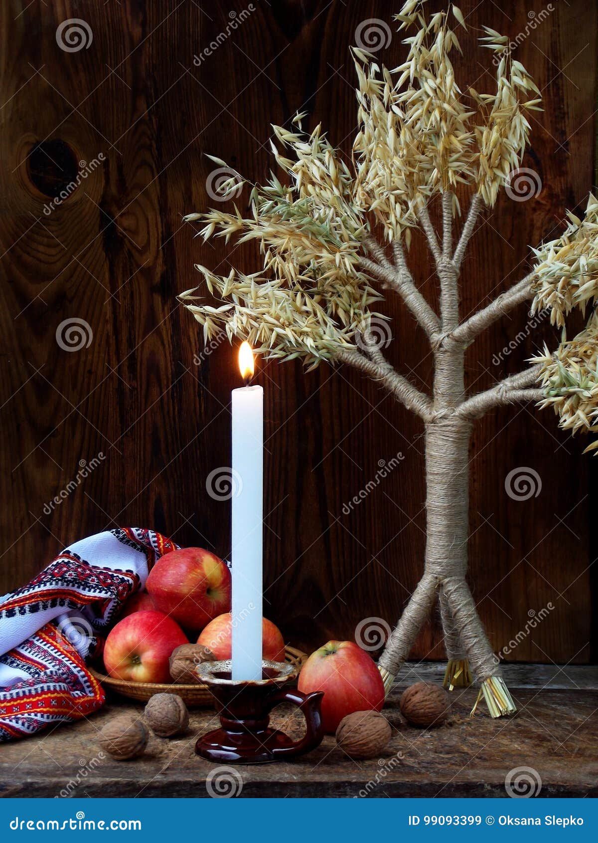 ukrainian christmas concept for greeting card. composition of xmas  didukh, burning candle, apples, walnuts on wooden backgr