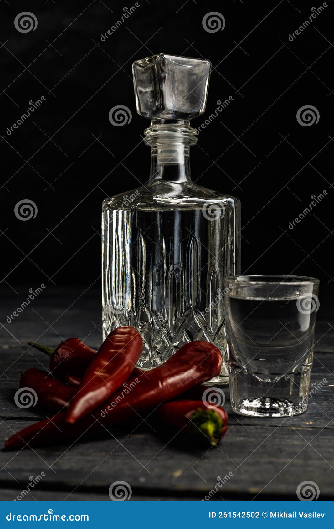 ukrainian gorilka or vodka or rum or tequila (transparent alcoholic drink) in jar and shot with red pepper