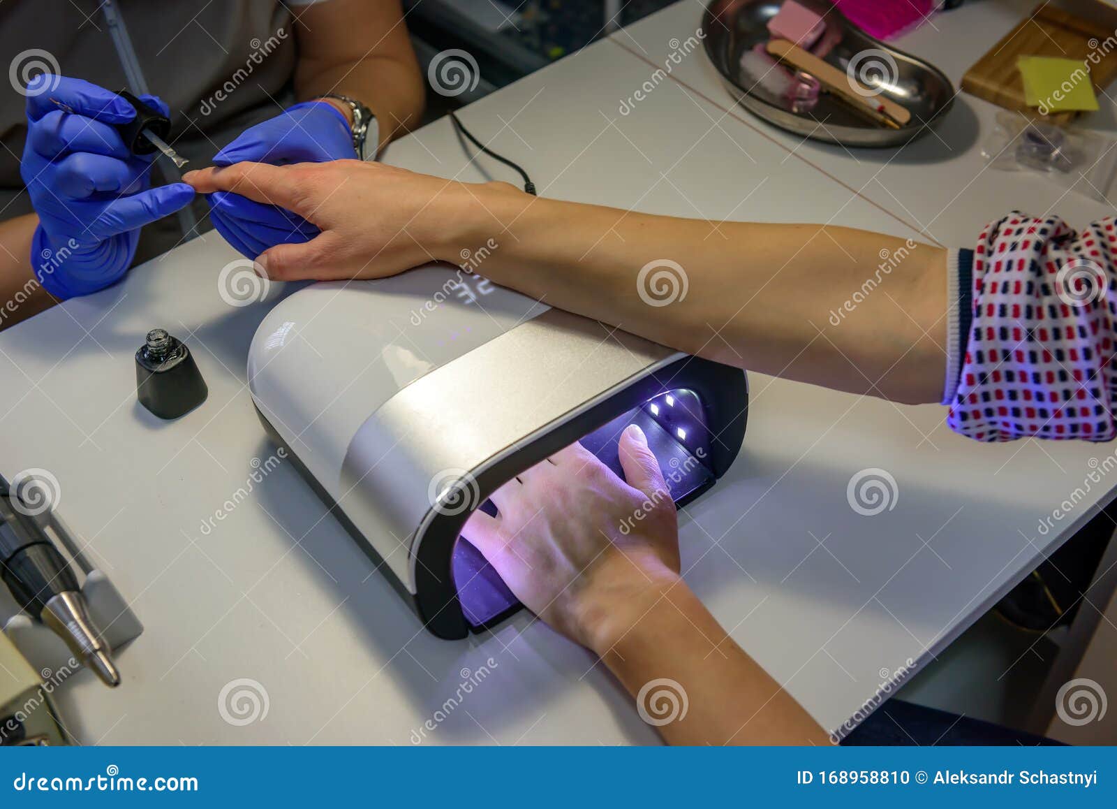 Ultraviolet Lamp In Manicure Salon. Young Woman Drying ...