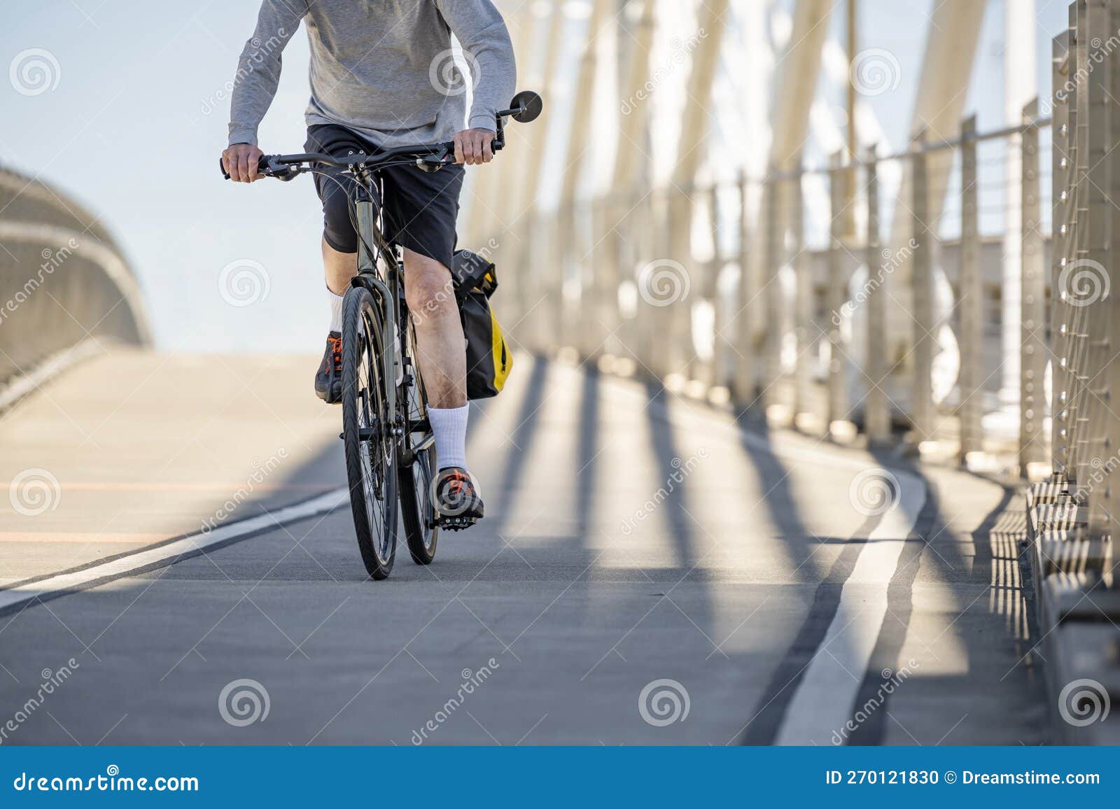 Um Ciclista Amador Idoso Do Sexo Masculino Faz Uma Bicicleta Caminhando Em Um Caminho Dedicado Na Ponte Foto de Stock