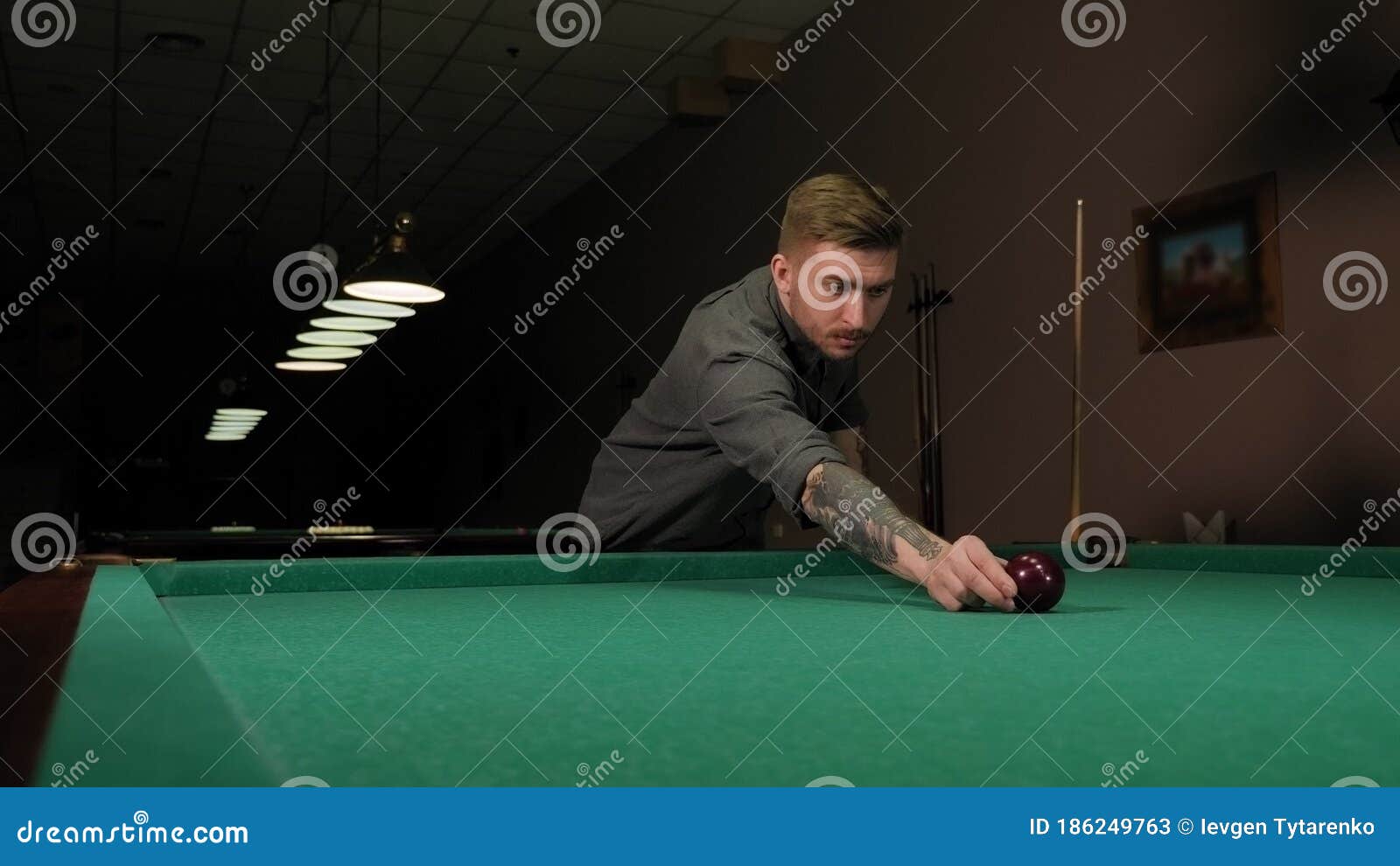 Mão do homem jogando sinuca no bar com bola de snooker