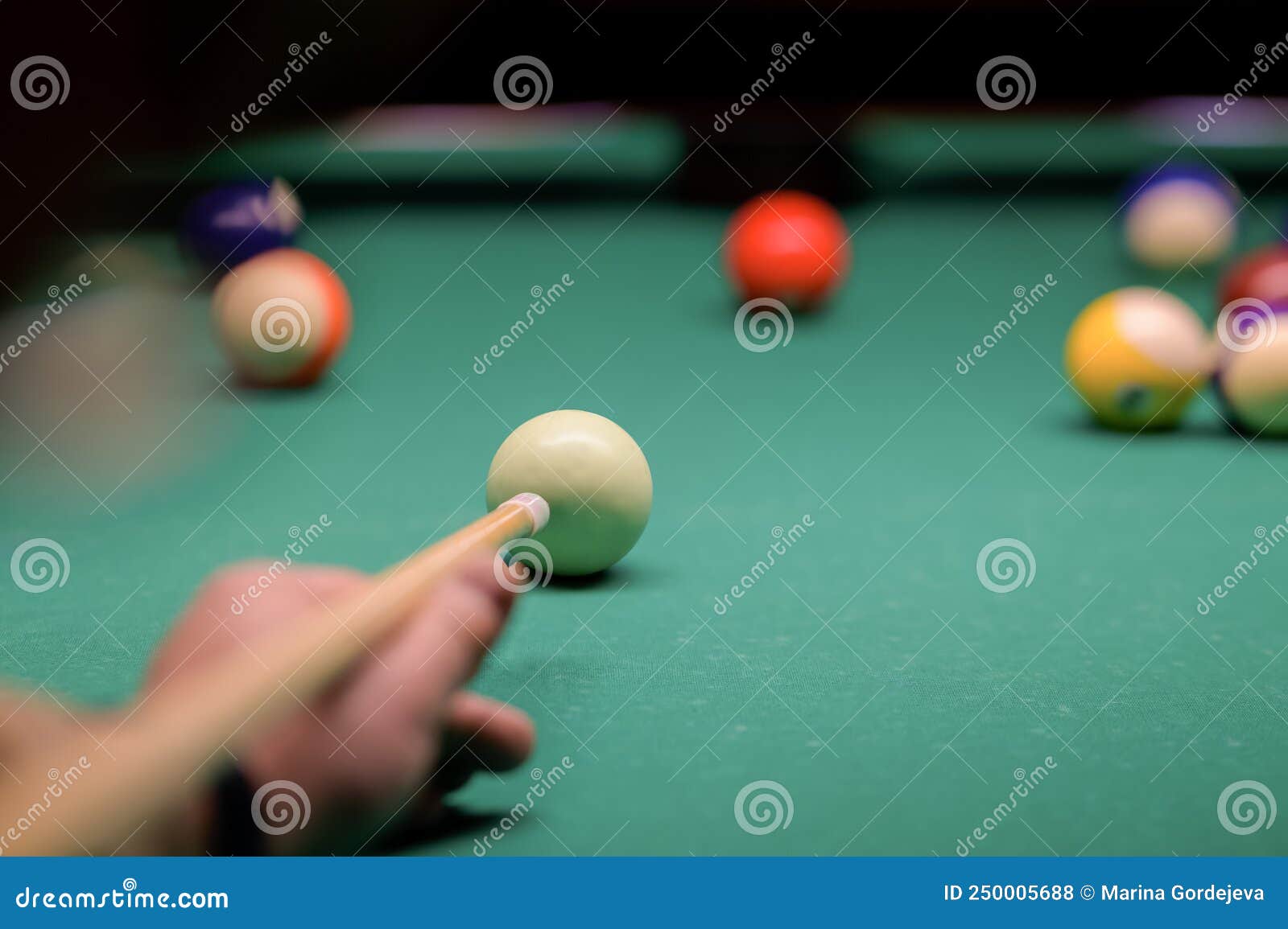 Mão do homem jogando sinuca no bar com bola de snooker