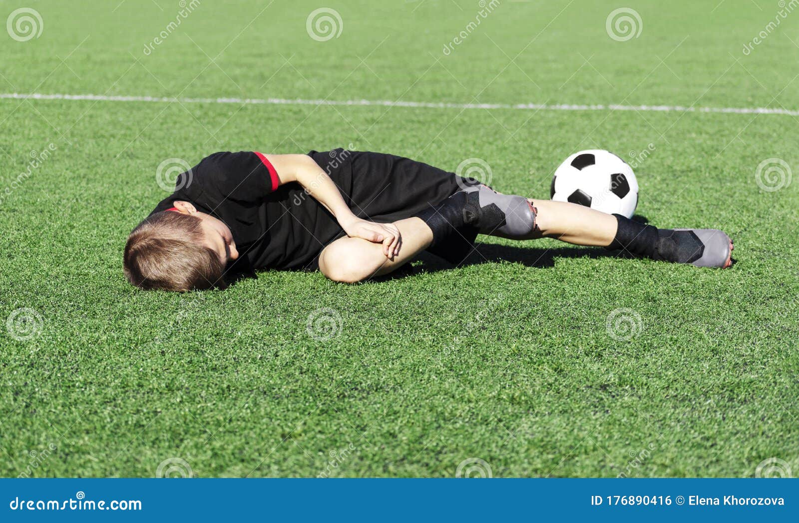 Um Jovem Jogador De Futebol Machucou Sua Perna Durante O Jogo E Bola No  Campo. Lesão Infantil No Conceito Desportivo. Cópia Foto de Stock - Imagem  de joelho, futebolista: 176890416