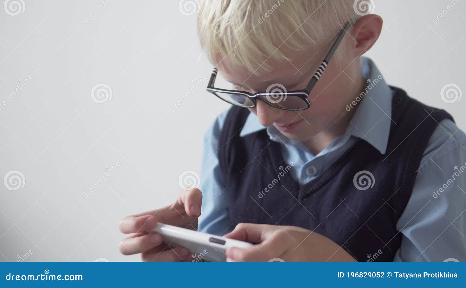 Um menino de óculos de sol deitado em uma rede colorida e jogando no  telefone jogos educativos no aplicativo para smartphone horário de verão a  criança usa o telefone o tempo todo