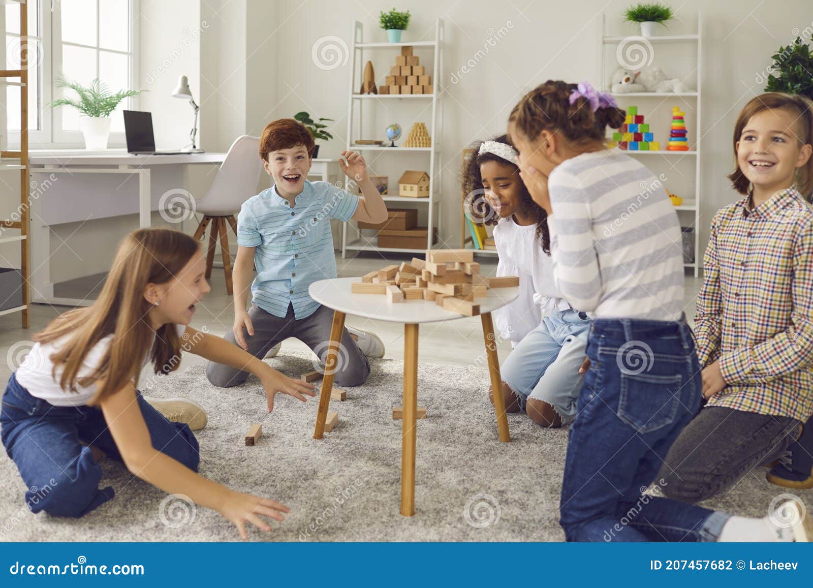 Jogando o jogo da torre de madeira grupo de crianças está junto em casa  durante o dia