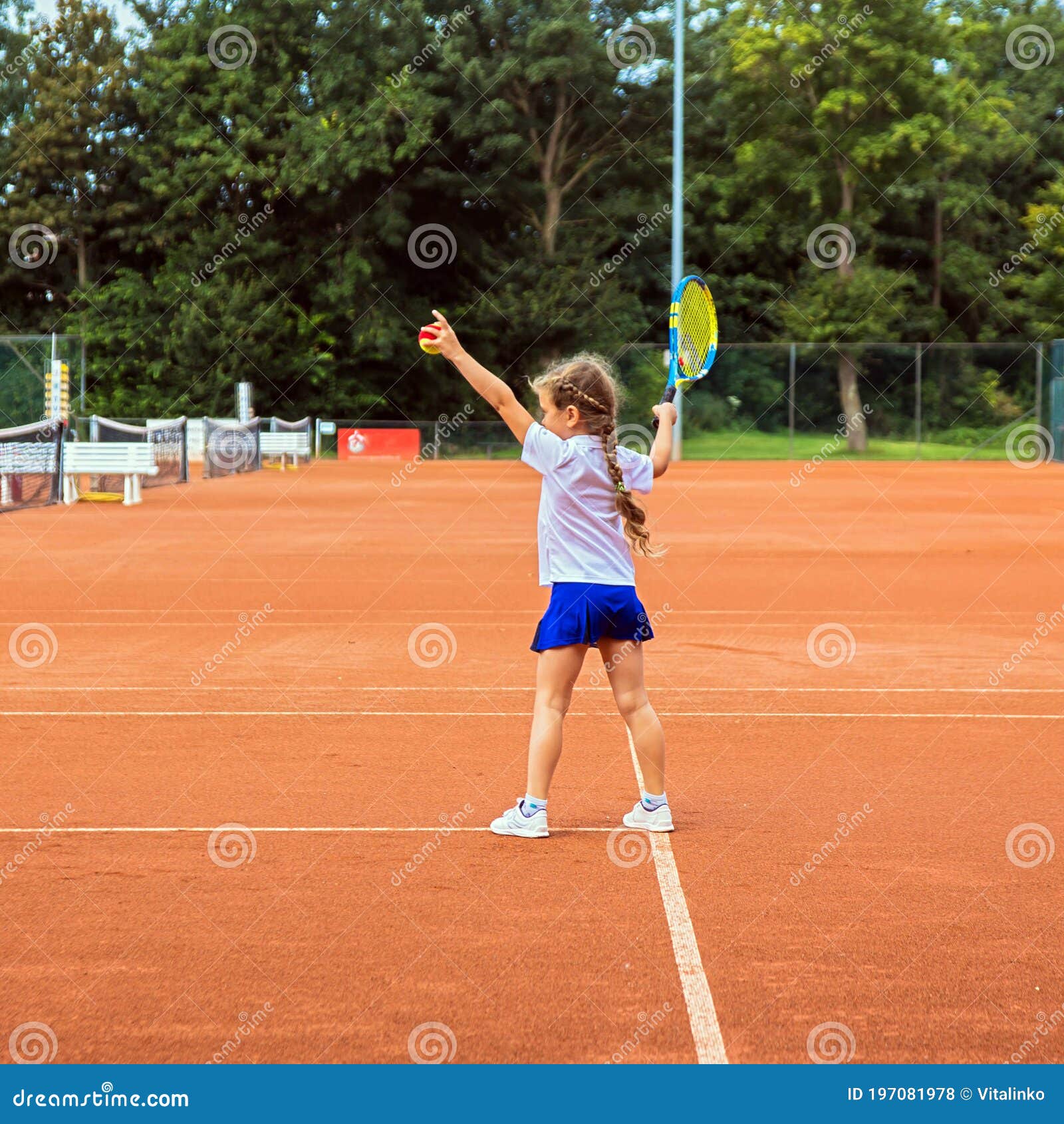 Foto de Tenista Infantil Em Roupas Esportivas Laranjas Com Raquete