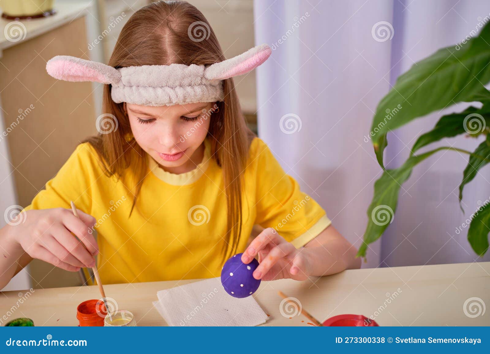 Caucasiana menina pintura com mãos coloridas pinta em casa