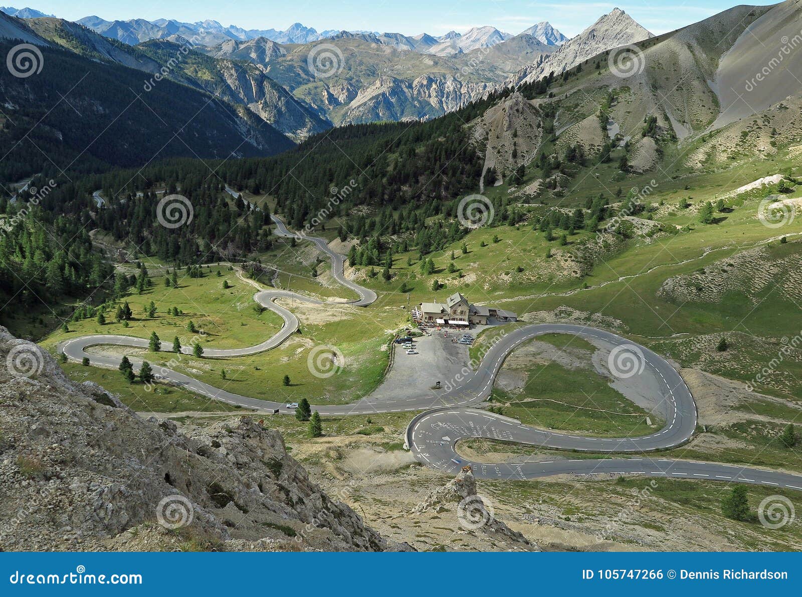 Uma estrada da montanha do enrolamento em França. Acima nos cumes pela beira italiana e francesa com uma estrada bendy, França