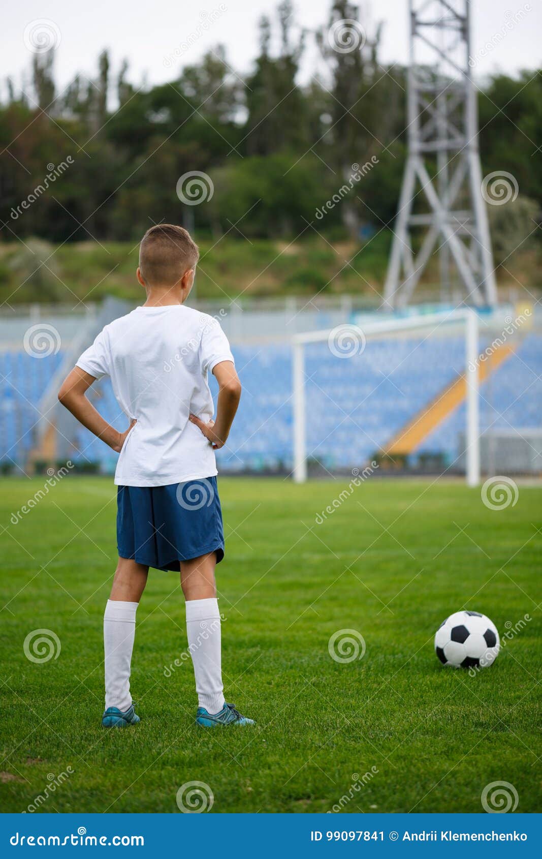 Jogador de futebol forte com bola de futebol e sorrindo em fundo branco  isolado
