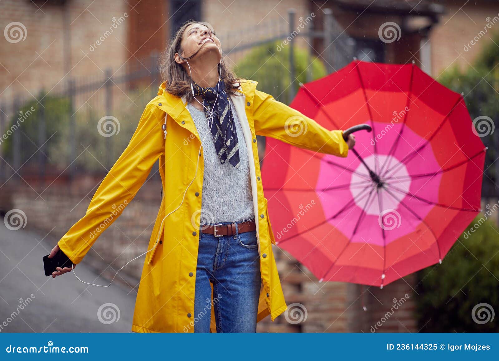 Uma Jovem Animada Em Uma Capa De Chuva Amarela Está Olhando Para O Céu Enquanto Escuta Música E Caminha Pela Cidade Em Um Dia Chuv Imagem de Stock - Imagem de exterior, Uma Jovem Animada Em Uma Capa De Chuva Amarela Está Olhando Para O Céu Enquanto Escuta Música E Caminha Pela Cidade Em Um Dia Chuv Imagem de Stock - Imagem de exterior,