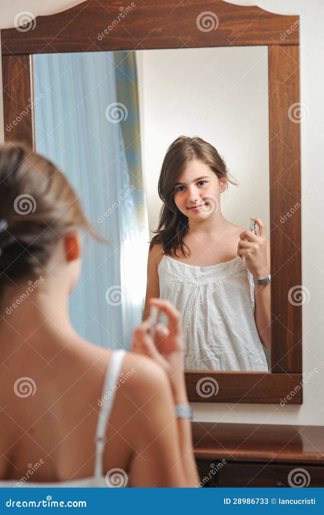 A Menina Bonita Olha Em Um Espelho Em Um Banheiro Foto de Stock - Imagem de  cara, adulto: 13967092