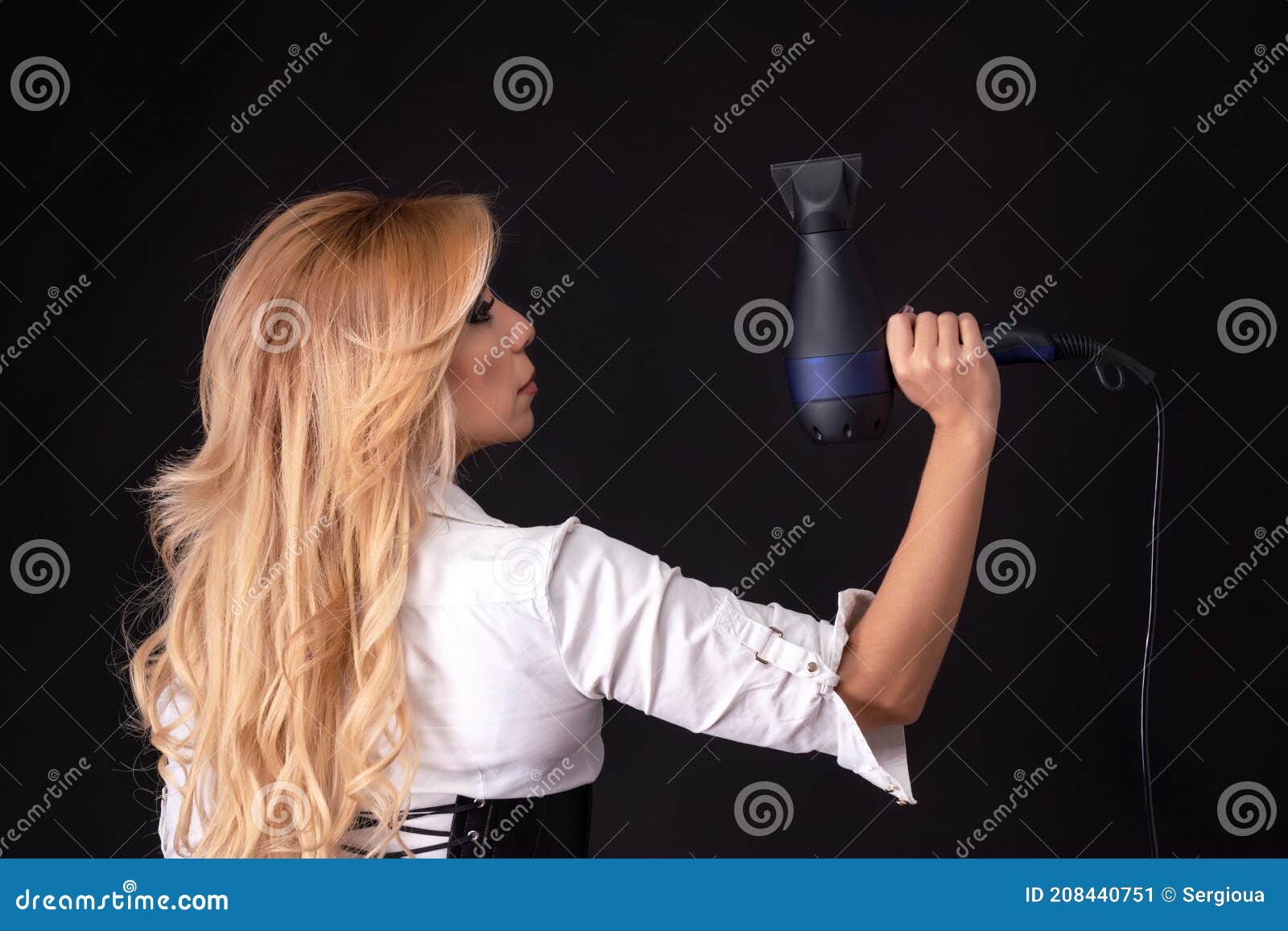 Mão feminina segurando secador de cabelo, isolado no branco