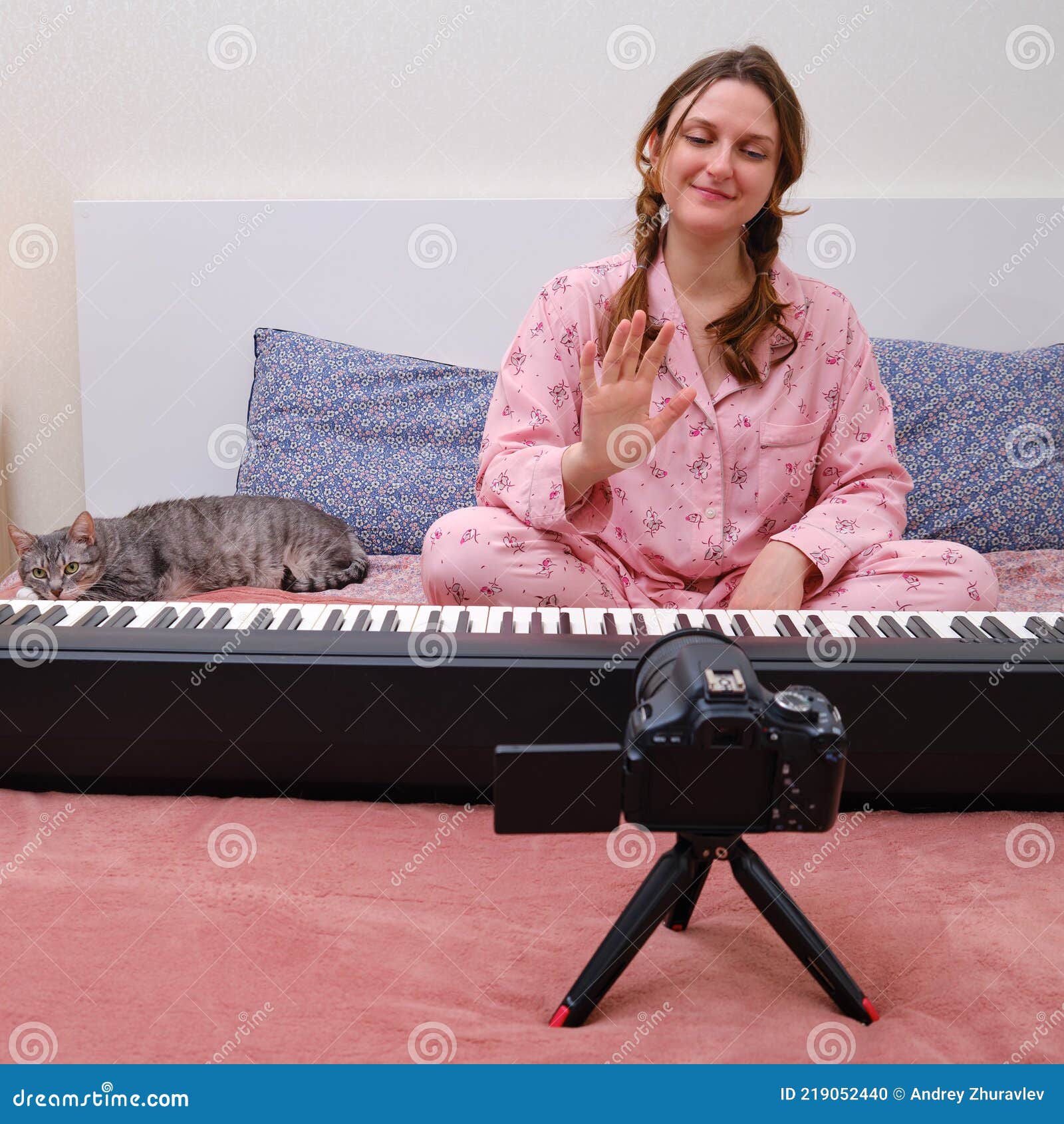 Uma Mulher De Pijama Rosa Está Transmitindo Um Jogo De Piano Online Na  Internet. Pianista Sorridente Mostrando Boas-vindas Com Ges Foto de Stock -  Imagem de quarto, interior: 219052440