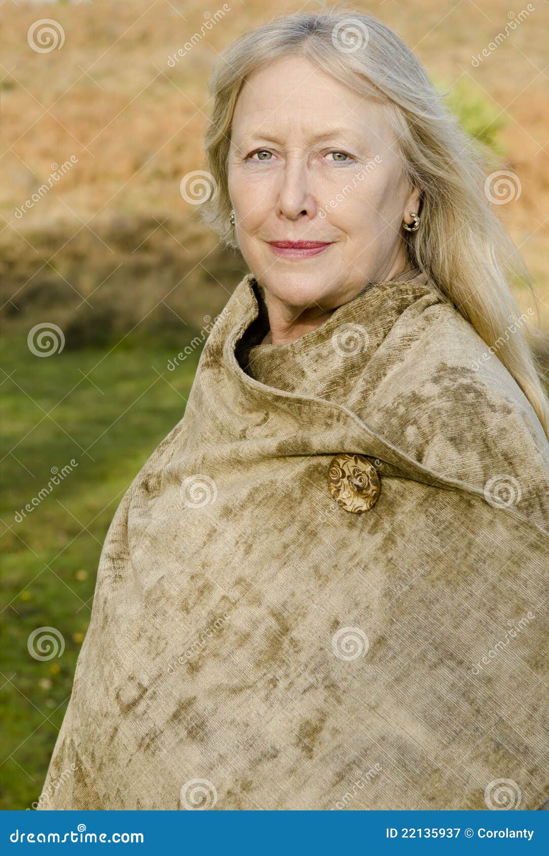 Uma mulher madura bonita em seus anos sessenta com cabelo louro longo e os olhos verdes