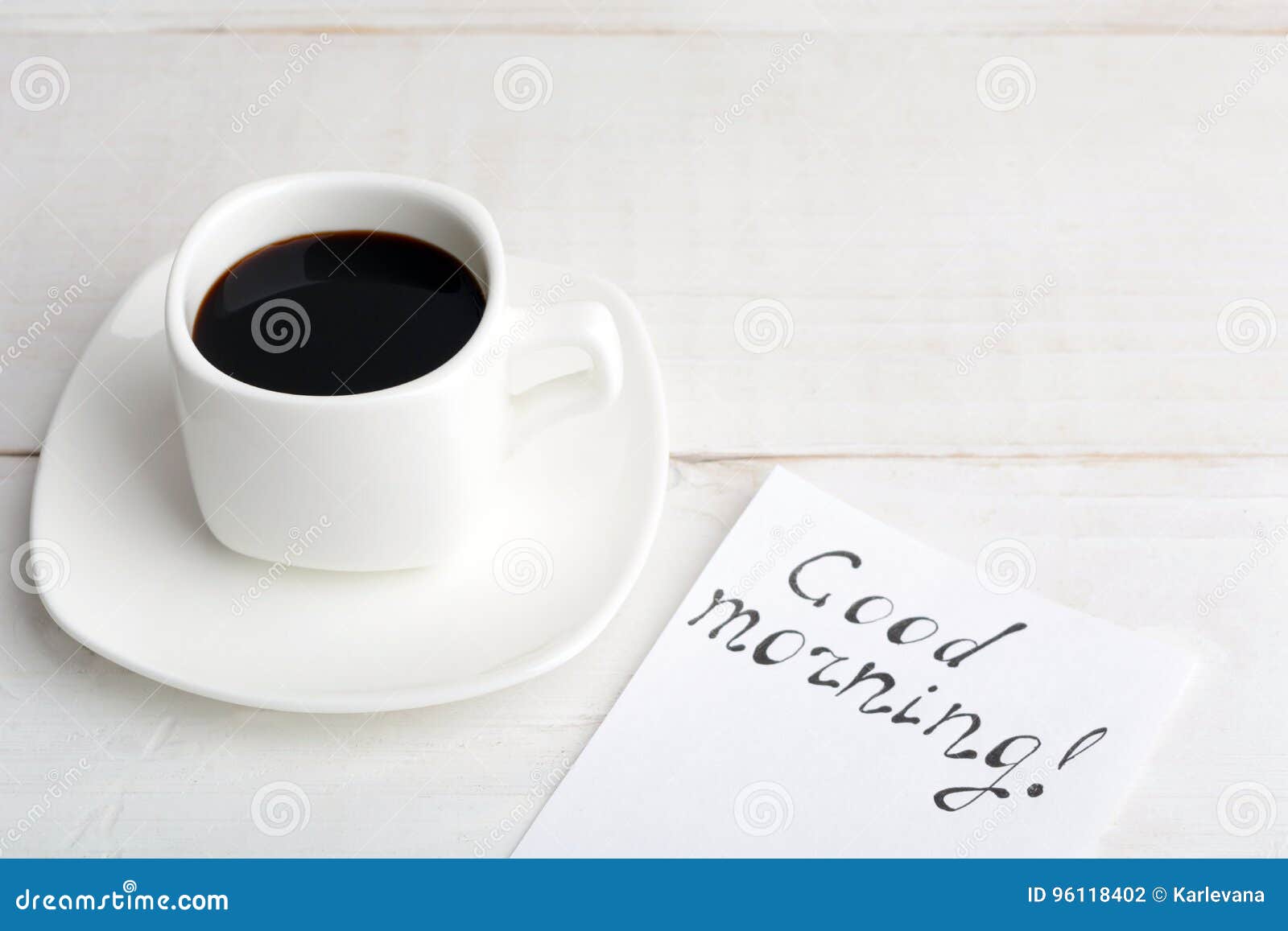 Uma Xícara De Café Com ` Do Bom Dia Do ` Da Mensagem No Tabl De Madeira  Branco Foto de Stock - Imagem de copo, simples: 96118402