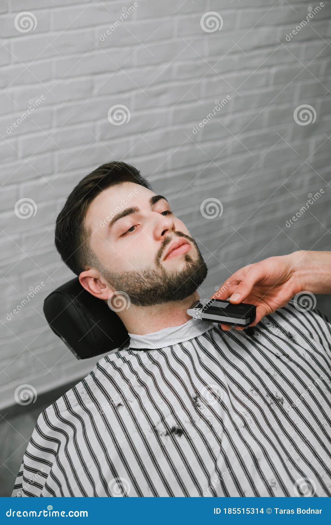 Un Barbero Profesional Hace Un Recorte De Barba En Sus Manos. Un Hombre Con  Barba Está En Una Silla Con Cara Seria Y Usa Foto de archivo - Imagen de  hombre, pista