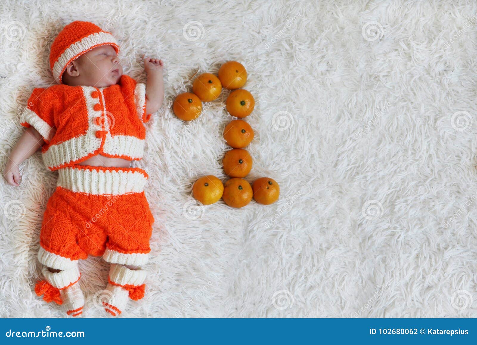 Bebé recién nacido en ropa naranja. un niño nacido en otoño